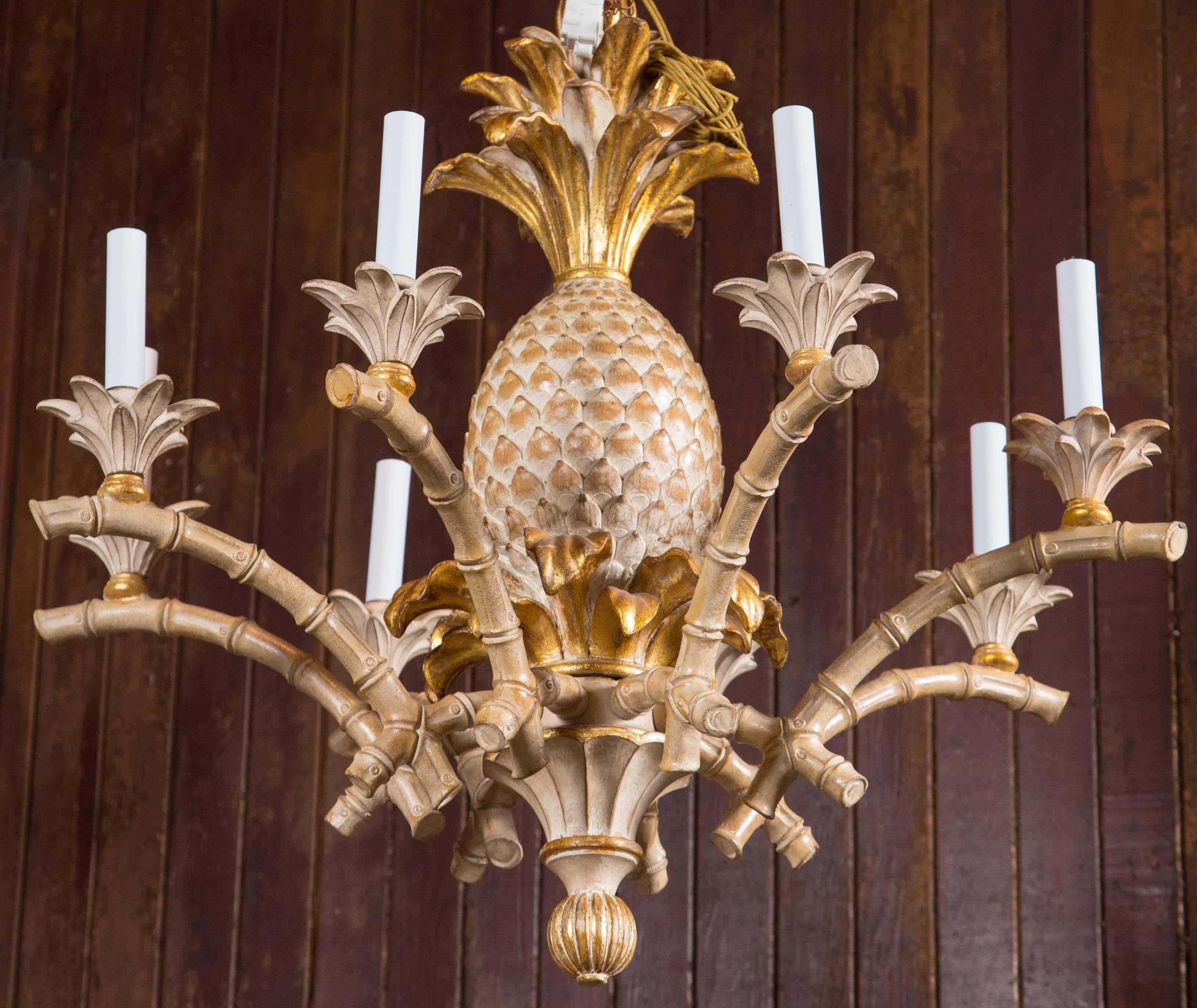 Italian carved solid wood pineapple, faux bamboo chandelier. Never used stock from the 1970s. Eight lights. Beautifully made light wood and gilt finish.