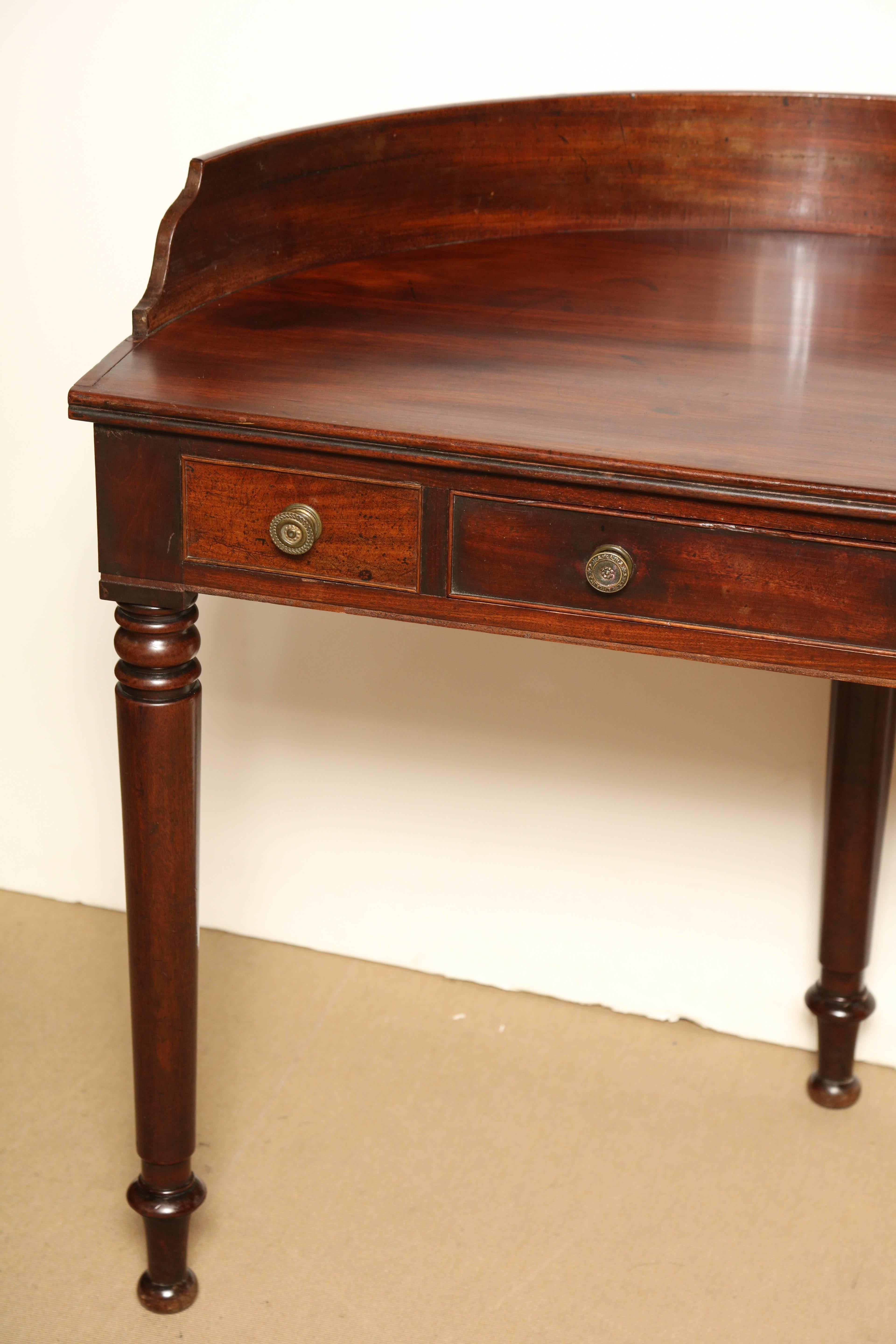 Mid-19th century Irish, Reverse demilune, mahogany desk-dressing table with one drawer.