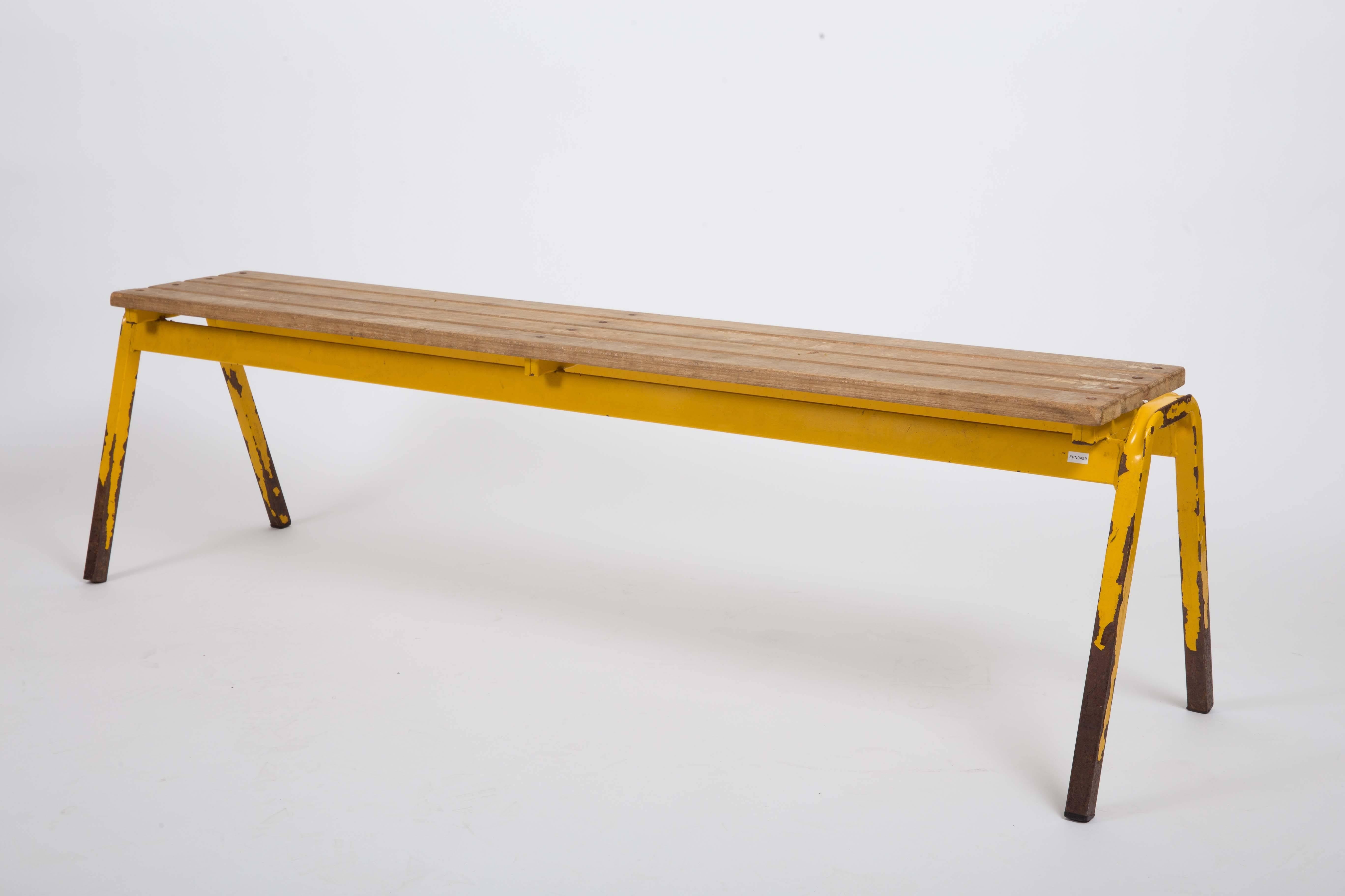 Vintage French industrial school bench with a slatted wood top, yellow metal framing, and charming patina on the legs. 

  