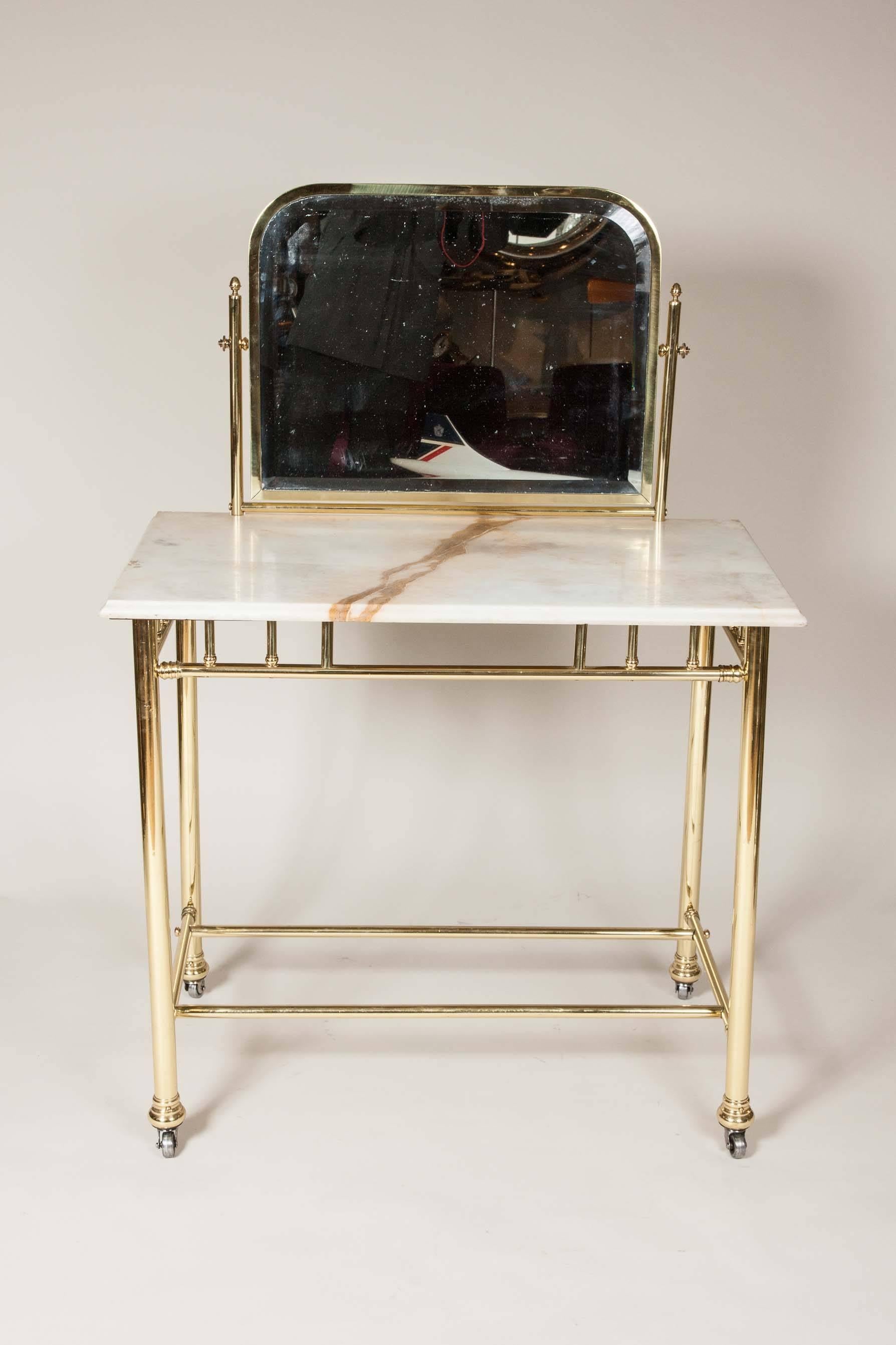 An Edwardian brass dressing table with tilting mirror and marble top.

