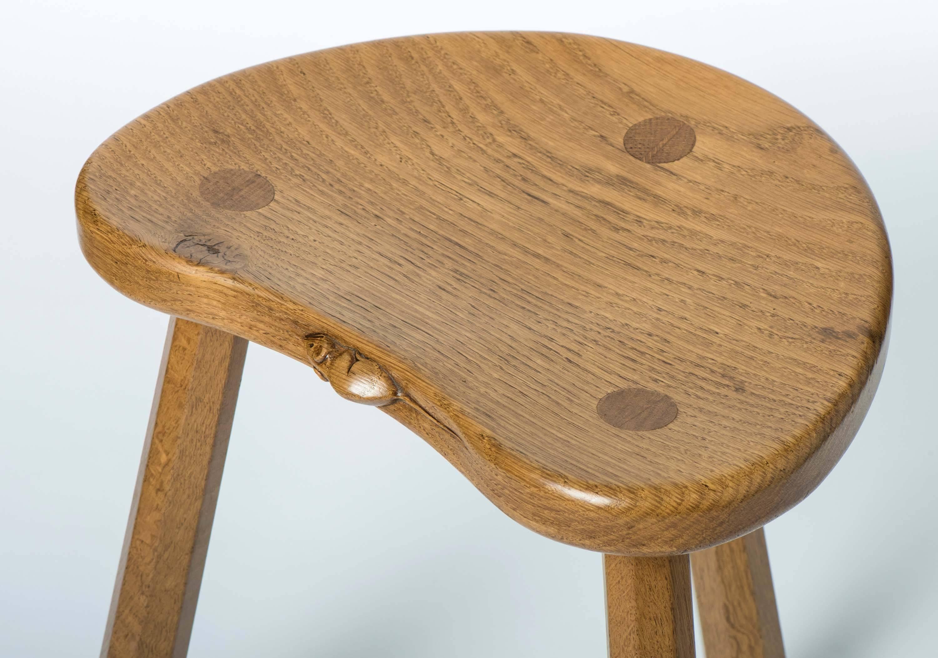 A Robert Mouseman Thompson milking stool.
The kidney shaped top set with three dowels.
With three octagonal splayed shaped supports.
Carved mouse to seat.
English,
circa 1970.
Measures: 46 cm H x 36 cm W x 30 deep.
              