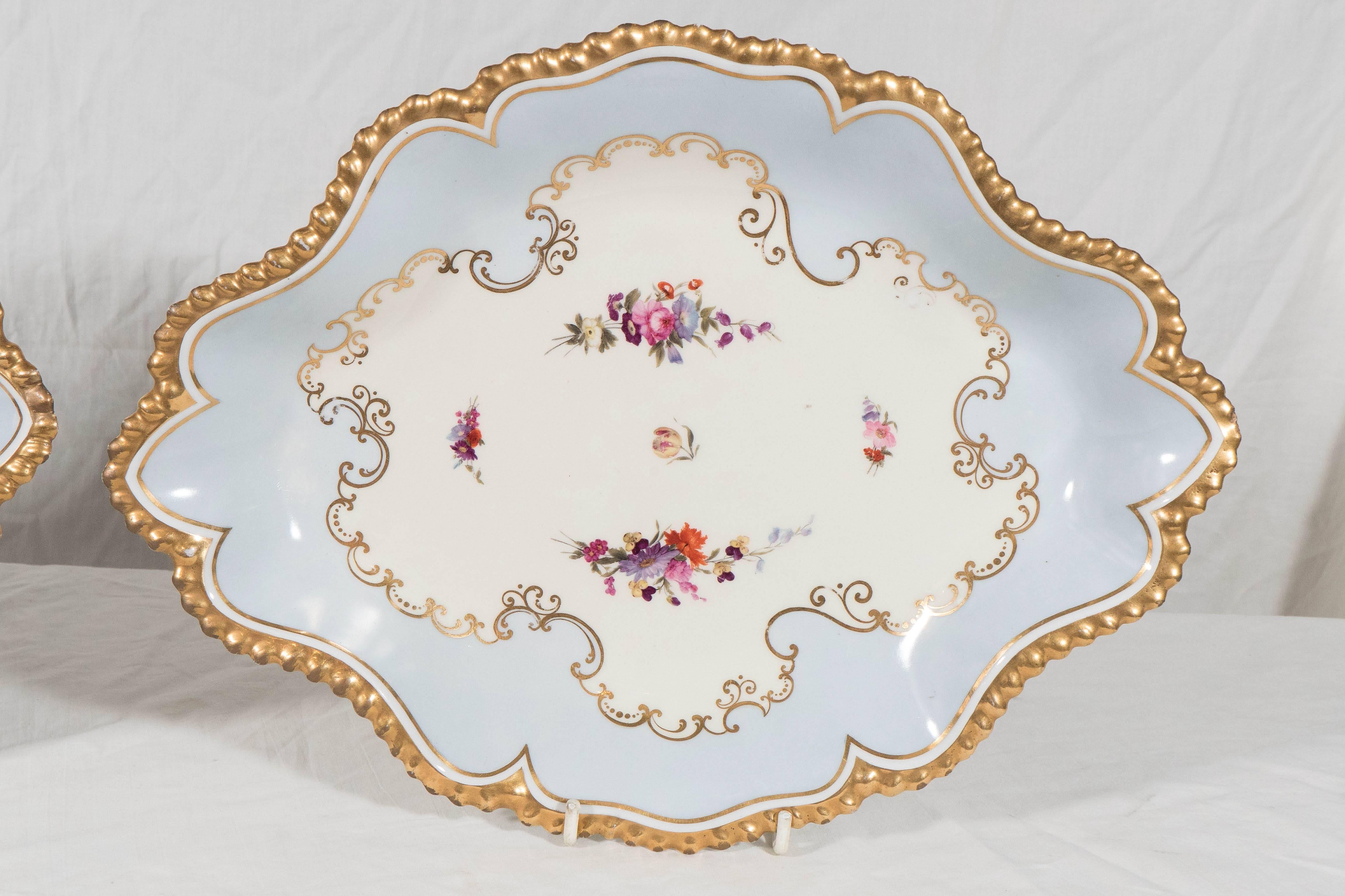  We are pleased to offer this Pair of Flight Barr & Barr Worcester oval-shaped dishes painted in baby blue with beautifully glided, gadrooned edges. England circa 1820
In the center are sprays of hand-painted pink and purple flowers on a white