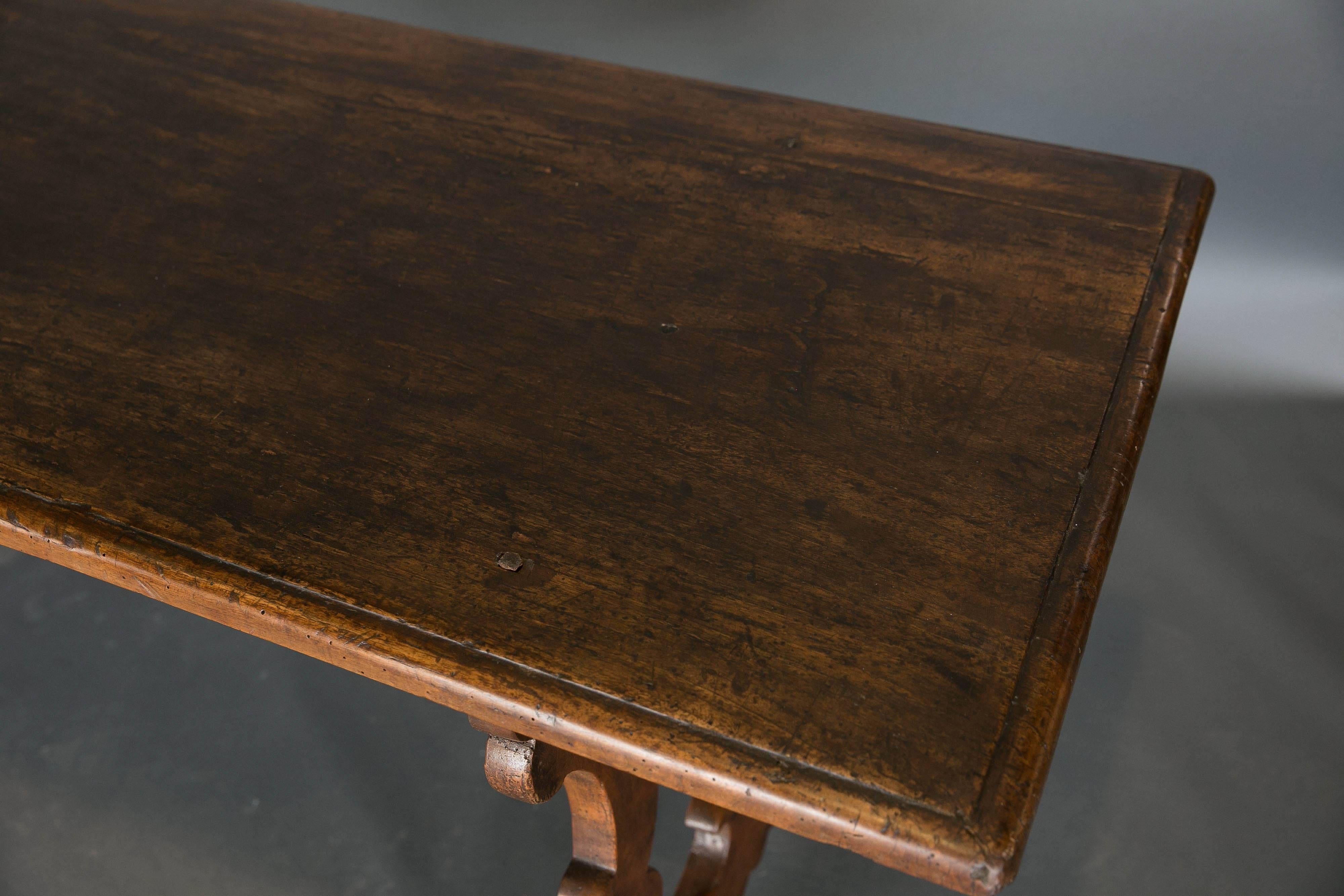 Antique 18th century Italian walnut table with a single plank top and wooden stretchers. Beautiful patina.