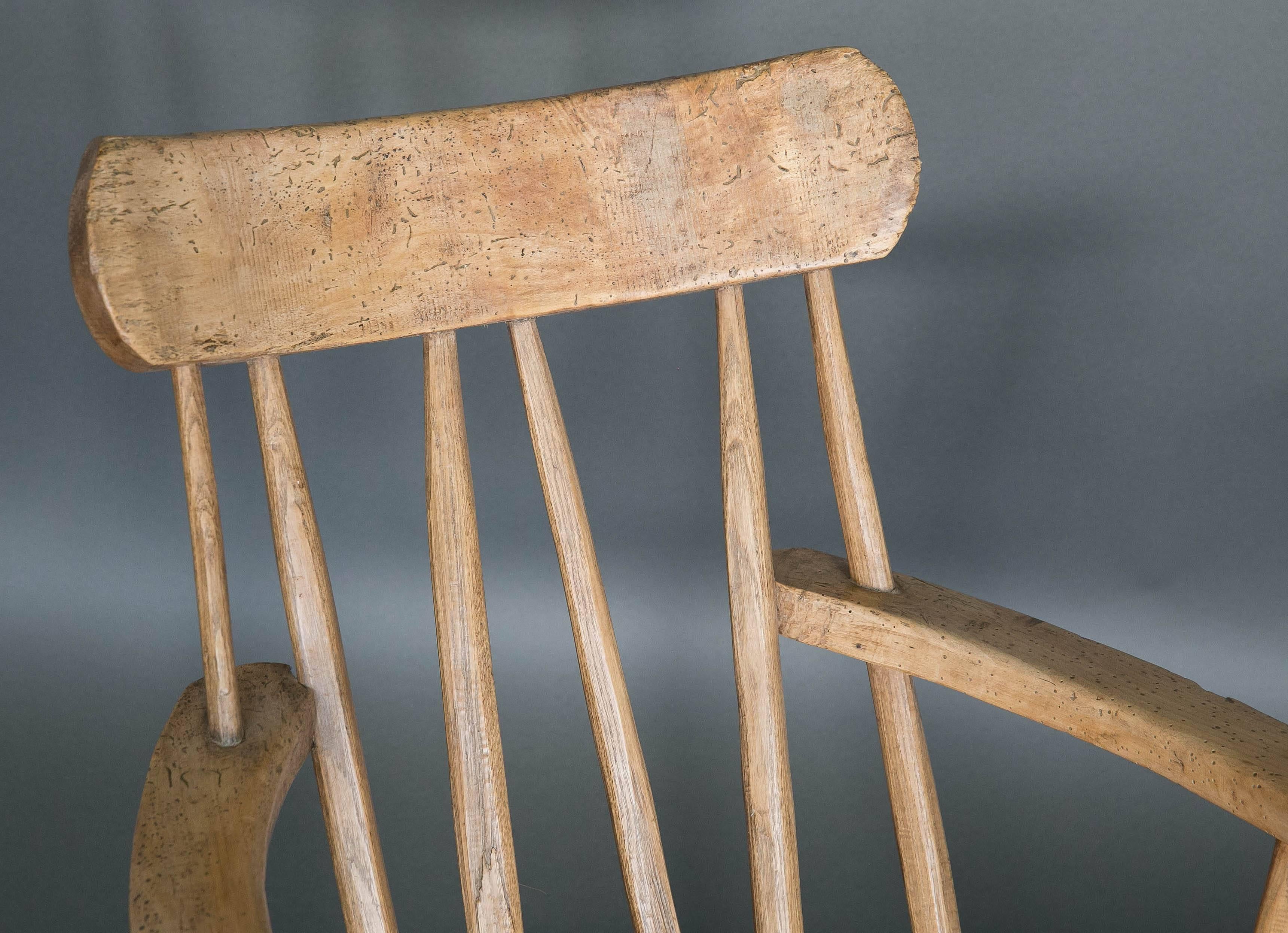 19th century English Folk Art stick chair made out of elm. Surprisingly comfortable and worn on the ends of the arms where someone would have handled to raise themselves from a sitting position. Seat height is 15.5 inches.