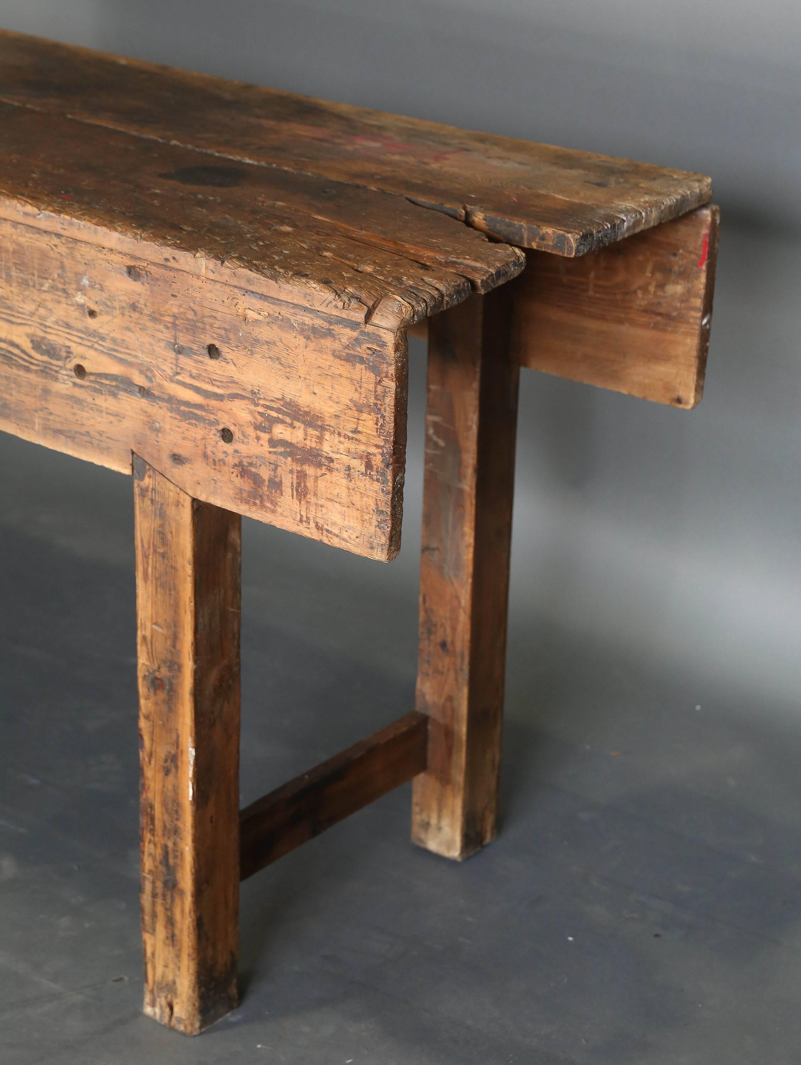 19th century French workbench with original vise. On right side of table a knot in the wood created the missing piece but does not detract from the workbench.
