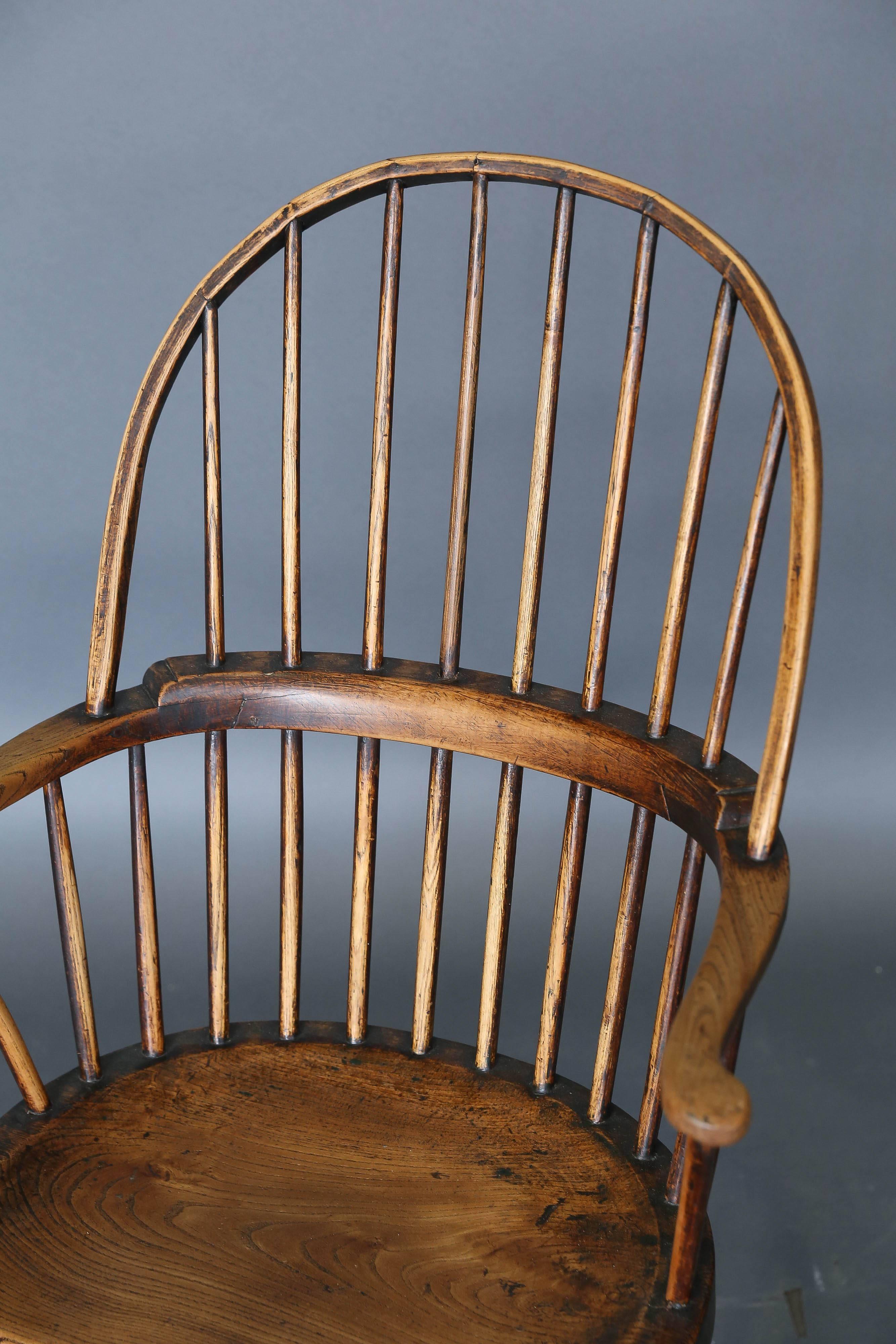 Antique 18th century ash and elm windsor chair from England with simple elongated bobbin stretchers. Comfortable and elegant. Worn appropriately where hands were placed.