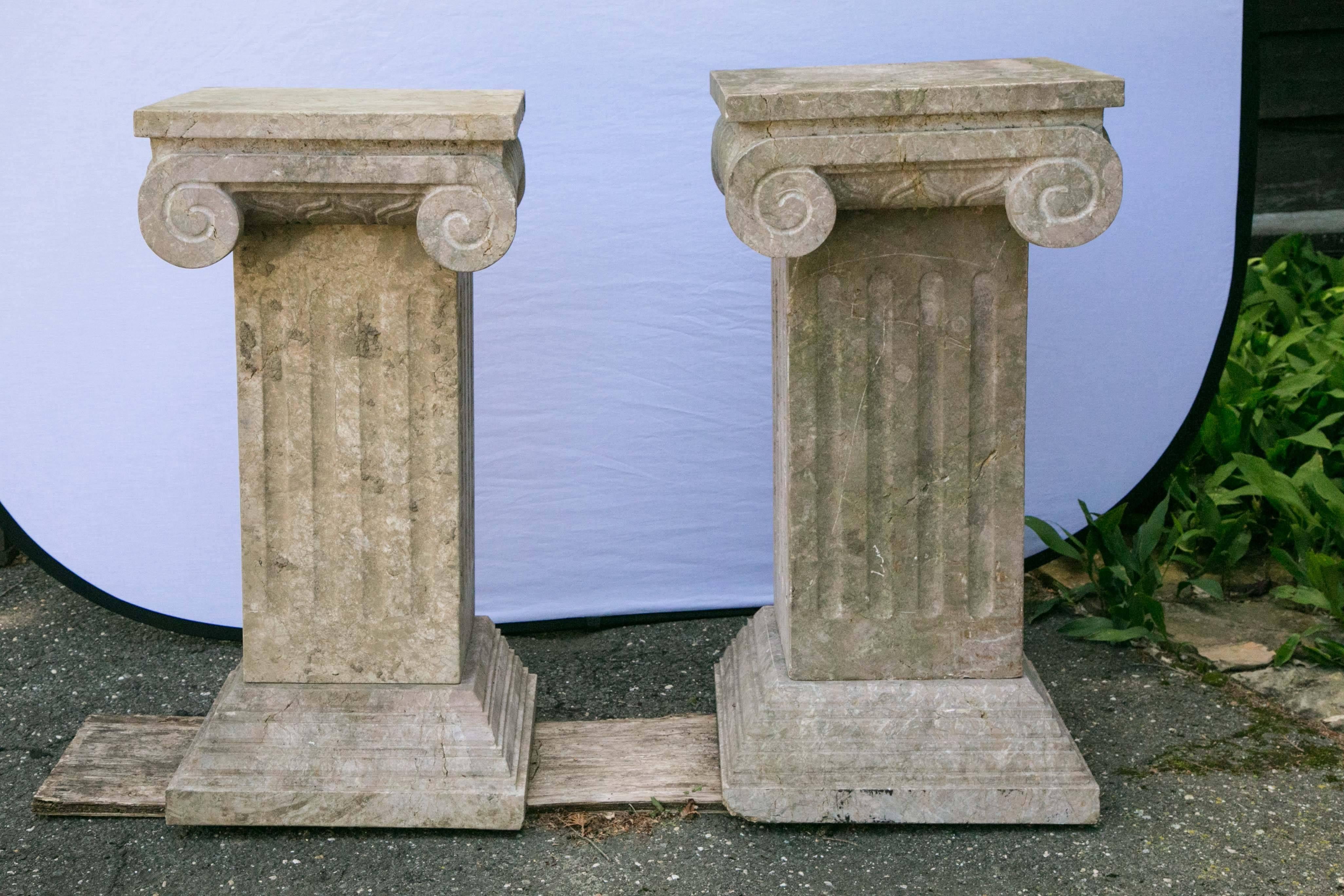 Pair of carved marble corinthian form capitals having fluted columns and stepped bases.
