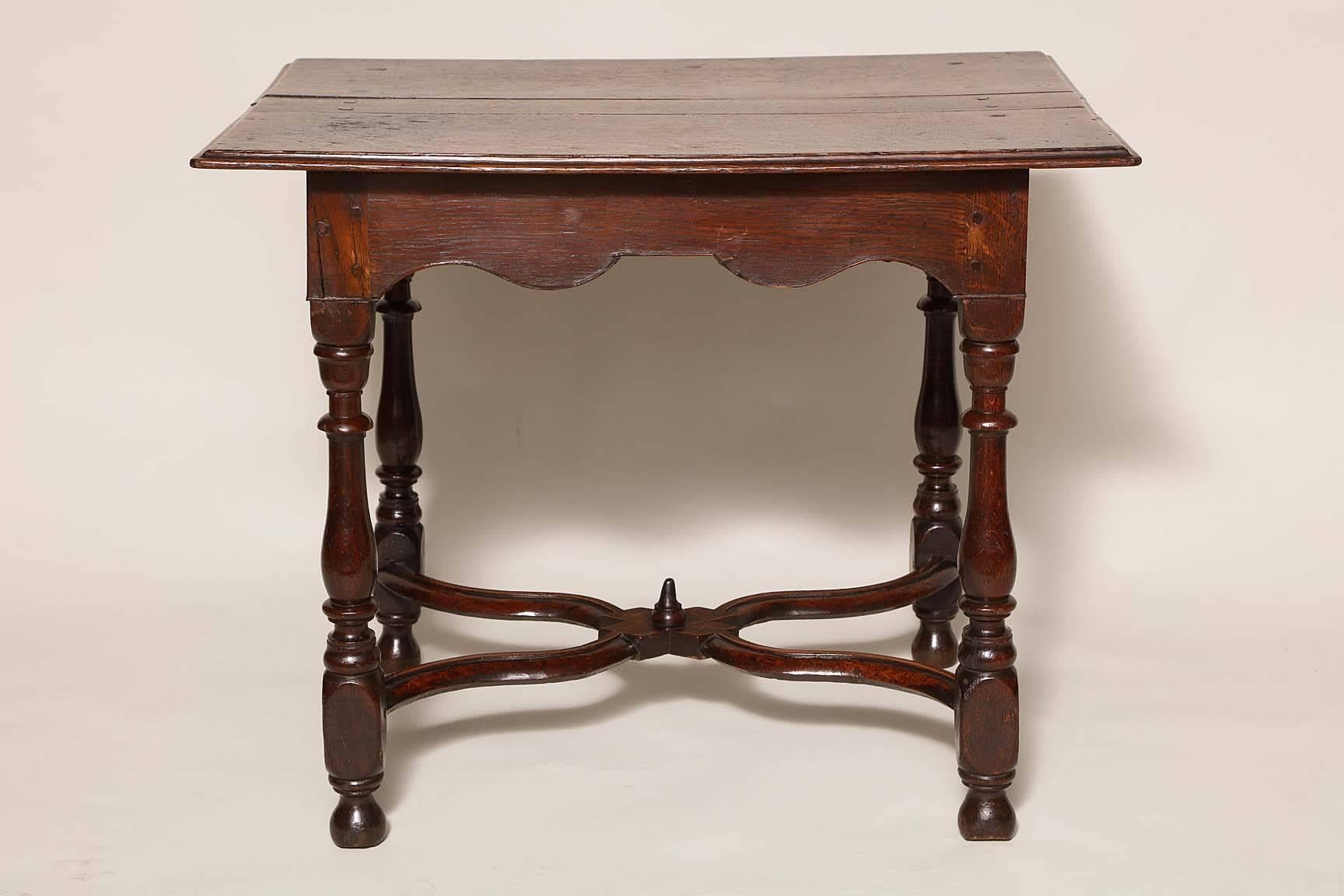 Very fine William and Mary period oak center table, the two plank top with ogee molded edge, over scalloped apron with applied edge, standing on balustrade turned legs joined by wavy 