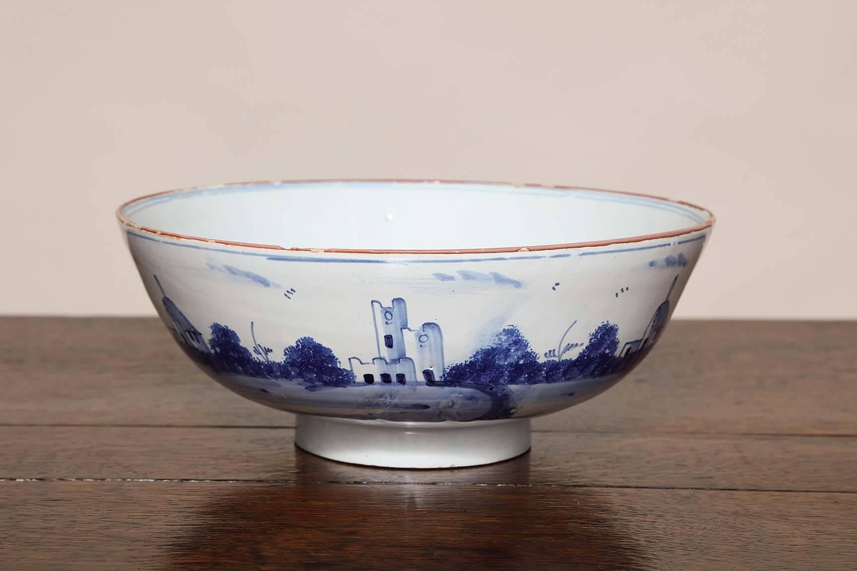 Fine 18th century delft punch bowl, the exterior with landscape scenes depicting cottages, castles and churches, the rim with orange glaze, the interior with simple white glaze with blur ring and in fine condition.

    
