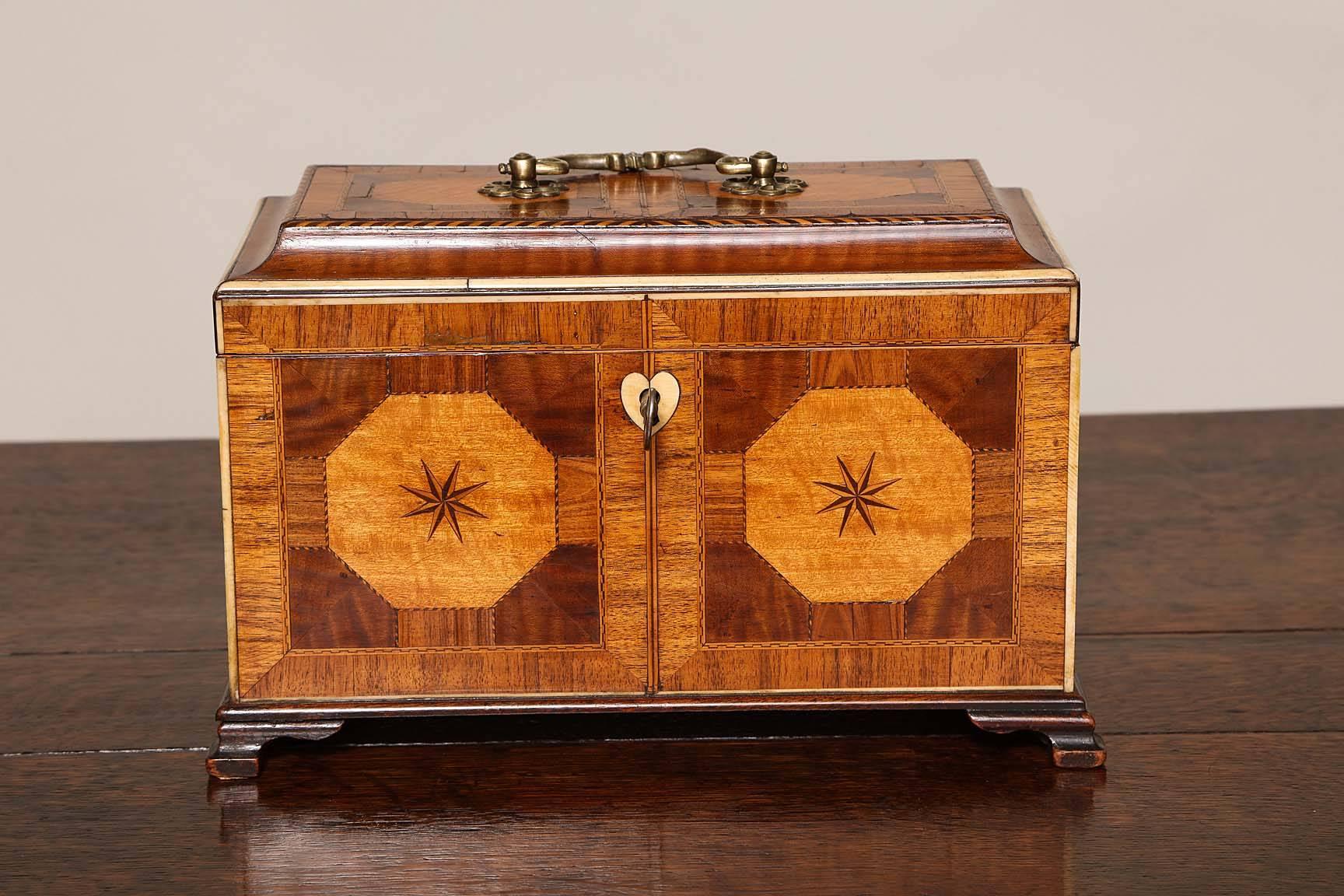 George III inlaid tea caddy of the finest quality with satinwood, rosewood, holly, ebony, mahogany and Guadeloupe wood marquetry and compass star inlay, the top with two octagonal satinwood panels with ebony and holly chevron stringing, the