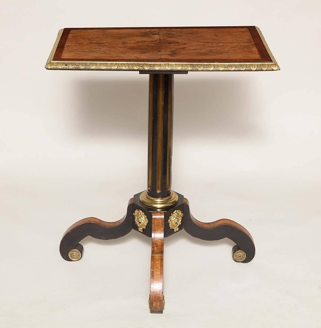 English early 19th century occasional table with ormolu mounts in walnut, rosewood and ebony veneer. The rectangular top with quarter veneered center in walnut, banded in rosewood, the edges trimmed in acanthus molded bronze on center shaft, the