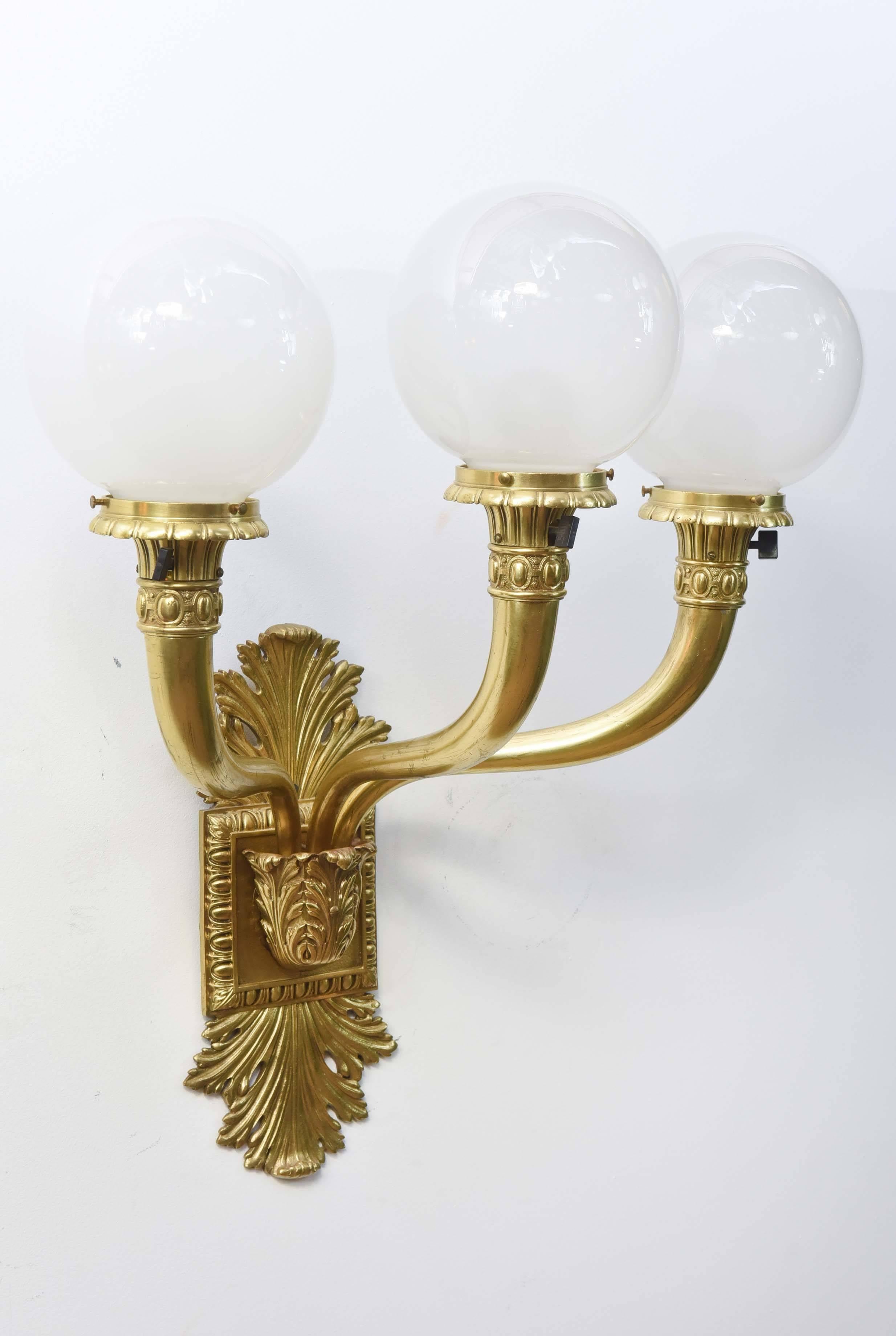 Cast brass large sconces, early electric, restored and rewired. The backplate is adorned with acanthus leaves with three arms.