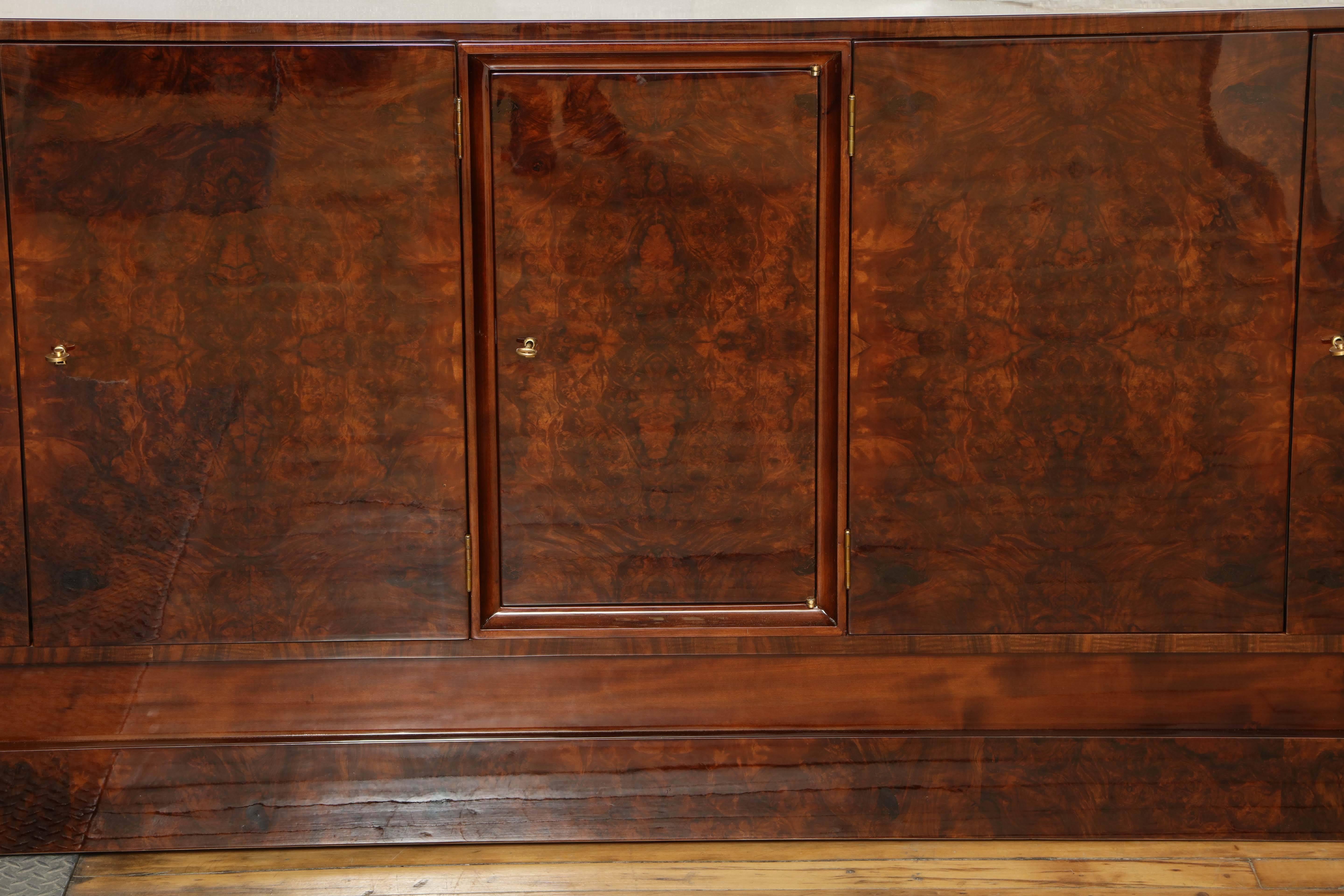 Walnut root wood.
Art Deco sideboard on floating base.
Ample storage space with multiple drawers and shelves inside.