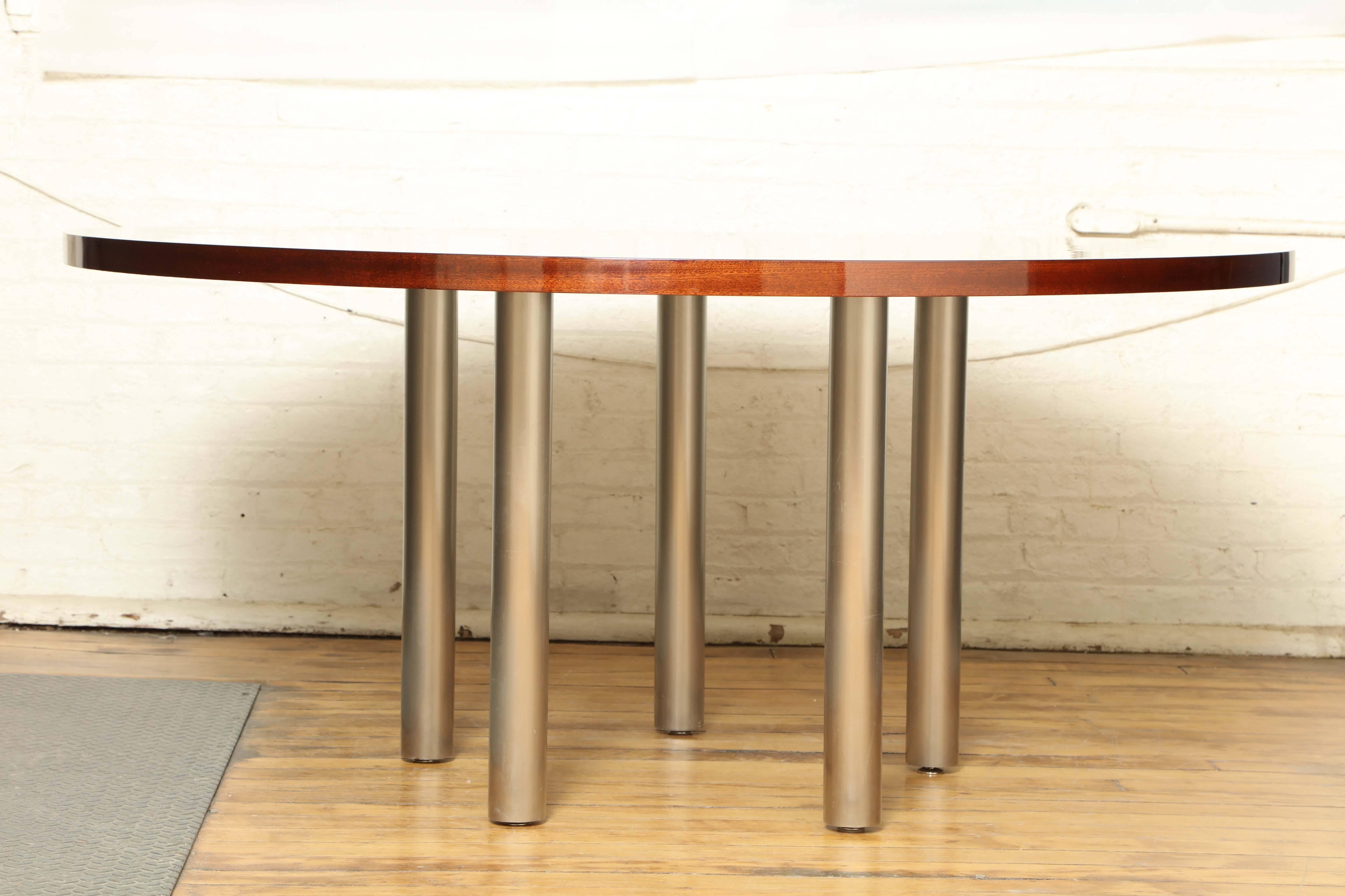 Mahogany round dining table with brushed steel legs.