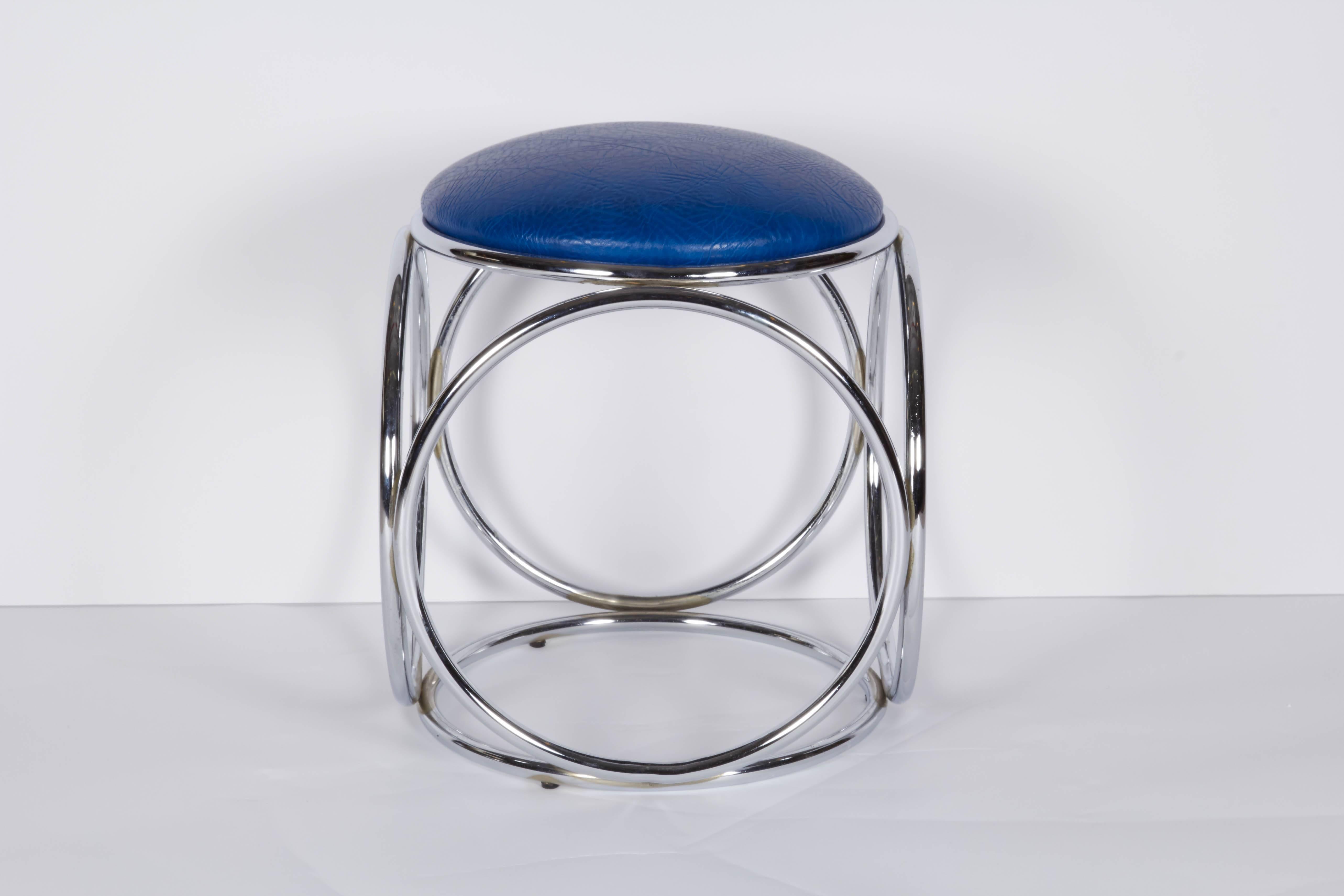 This circa 1970s stool, comes with round seat, upholstered in textured blue leather, on a chrome base, comprised of tubular rings. The stool remains in very good vintage condition, consistent with age; seat newly reupholstered.