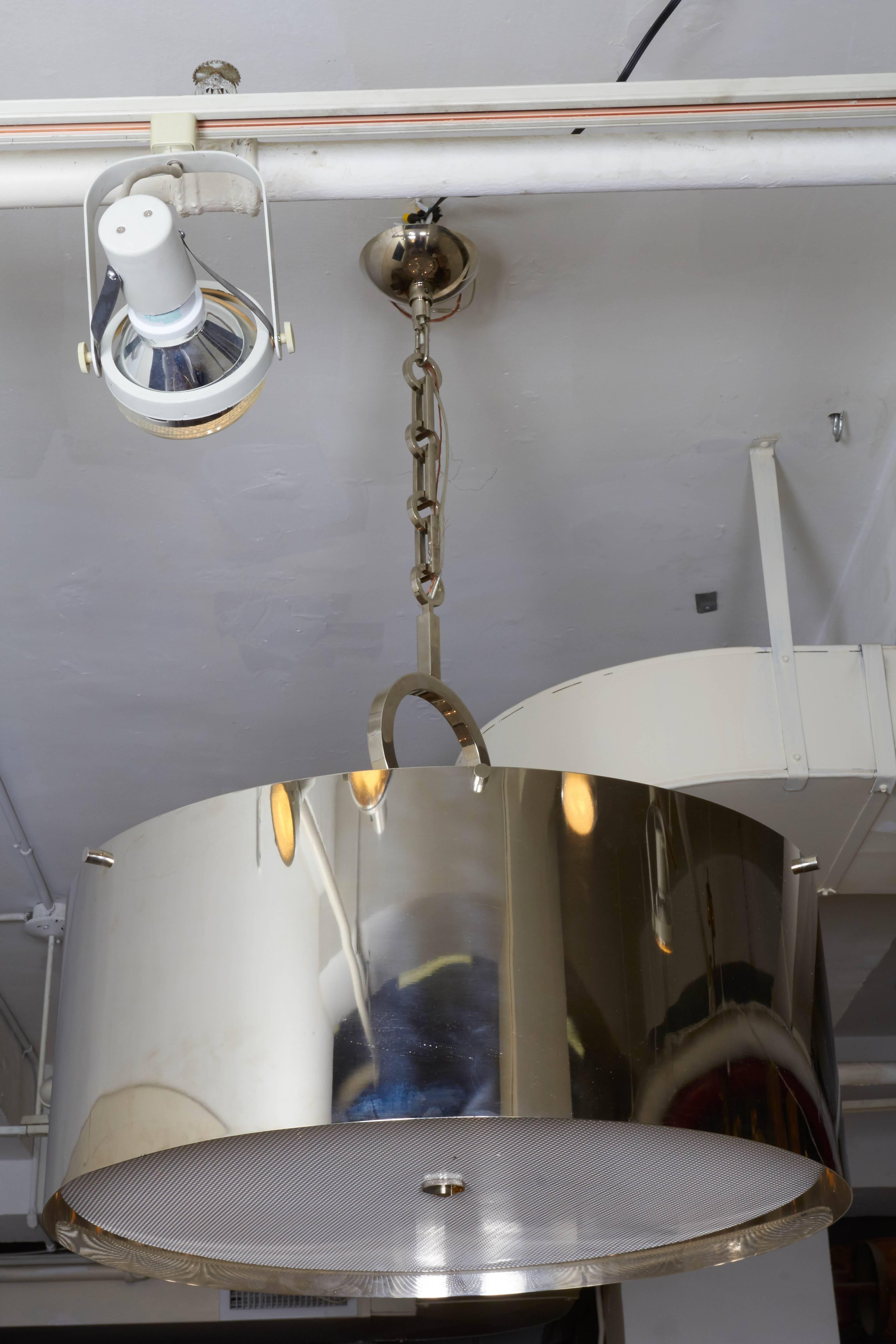 This six-light chandelier by Luminaire, produced circa 1970s to 1980s, includes a drum form shade, in polished nickel plating against brass base, suspended by unique geometric chain and original canopy. Requires six candelabra base bulbs. Markings