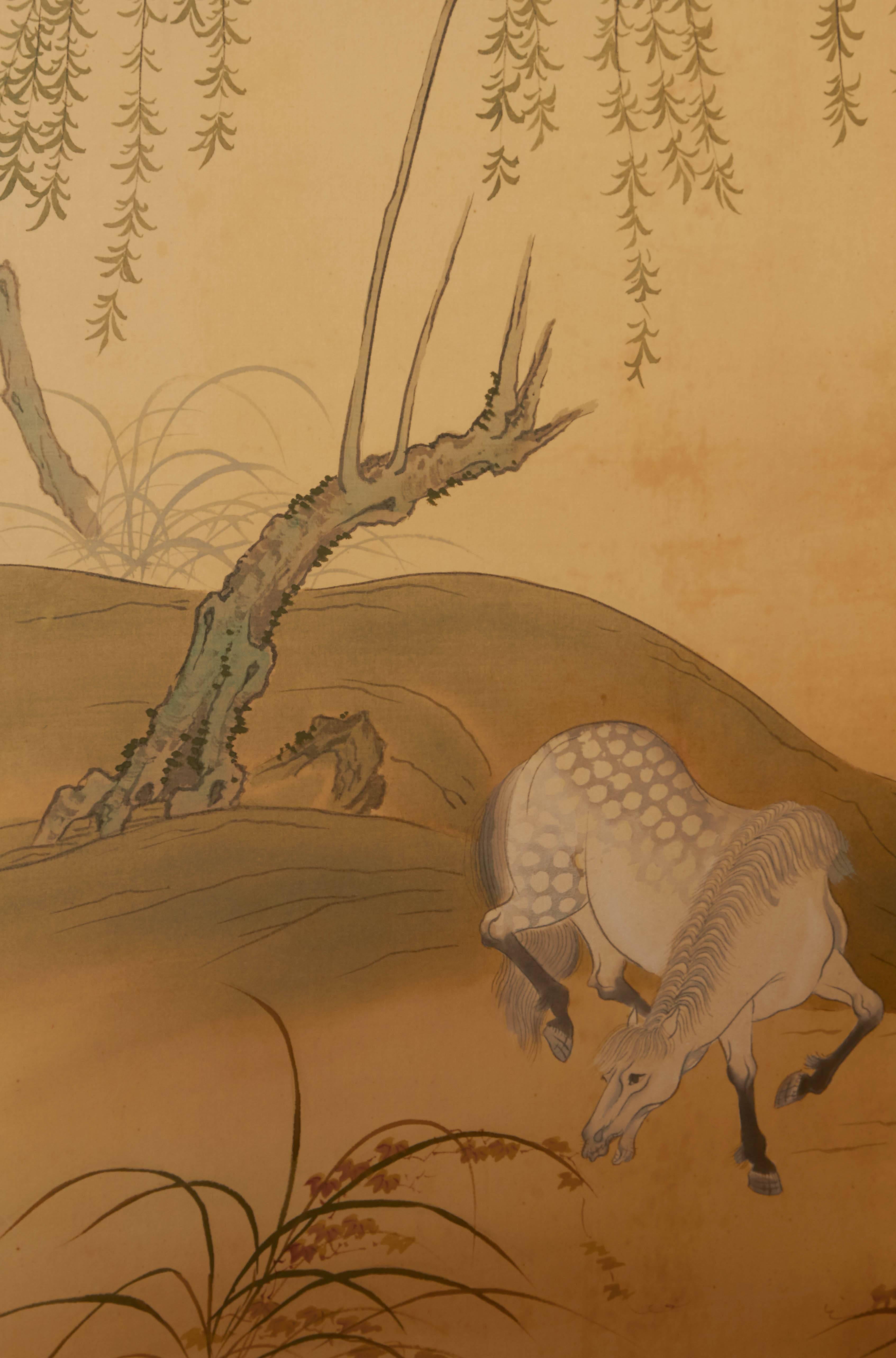 Paravent japonais à quatre panneaux, produit vers les années 1920, représentant des cavaliers domptant des chevaux dans un vaste paysage naturel ; motif shippo au verso. Très bon état vintage, conforme à l'âge et à l'utilisation.

#611.