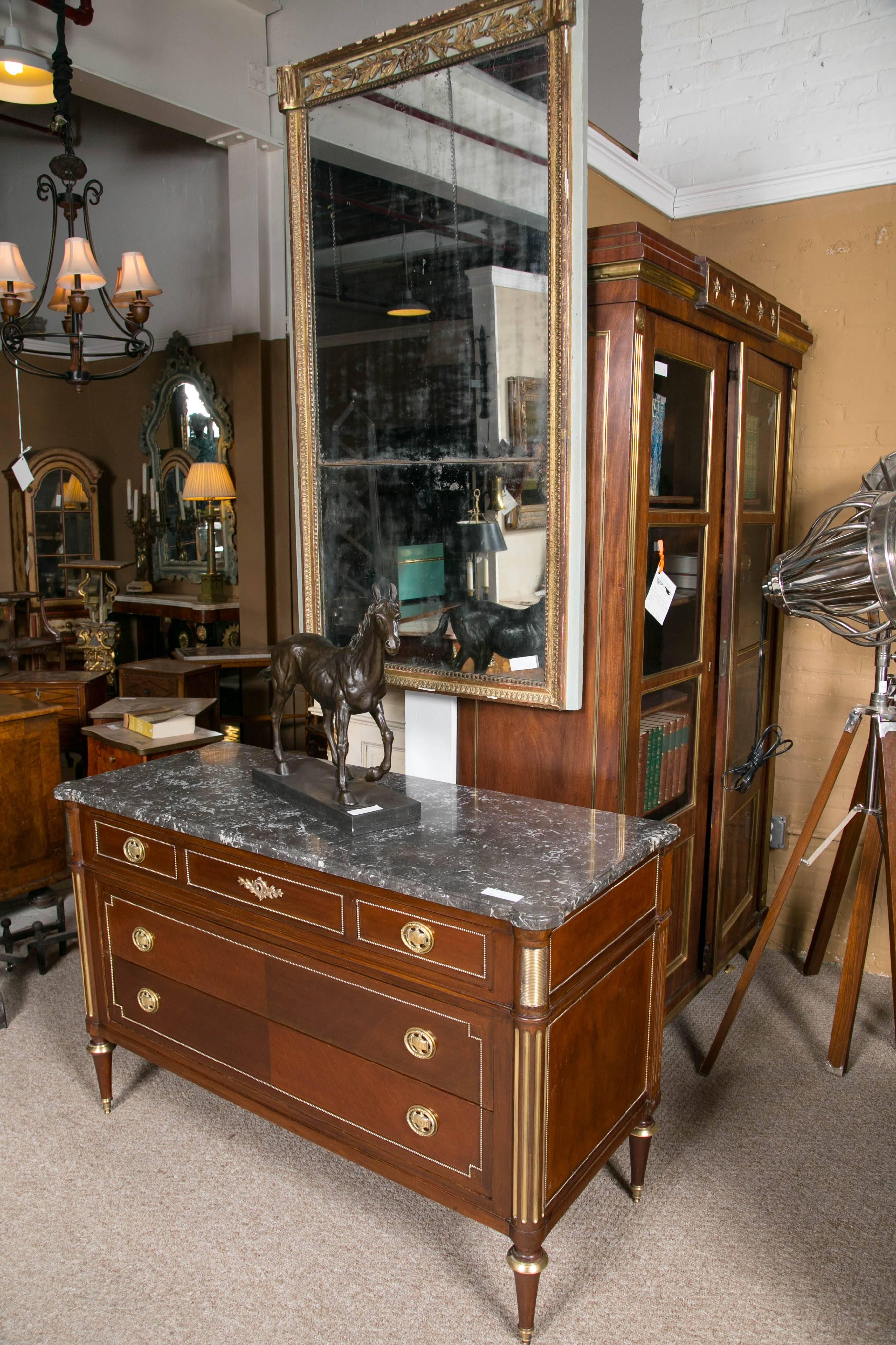 An early 19th century Directoire marble-top commode. Made in France this fine Louis XVI style commode has three drawers. The lower pair of drawers framed in order to appear as one drawer. The upper drawer is smaller in size. The overall casing