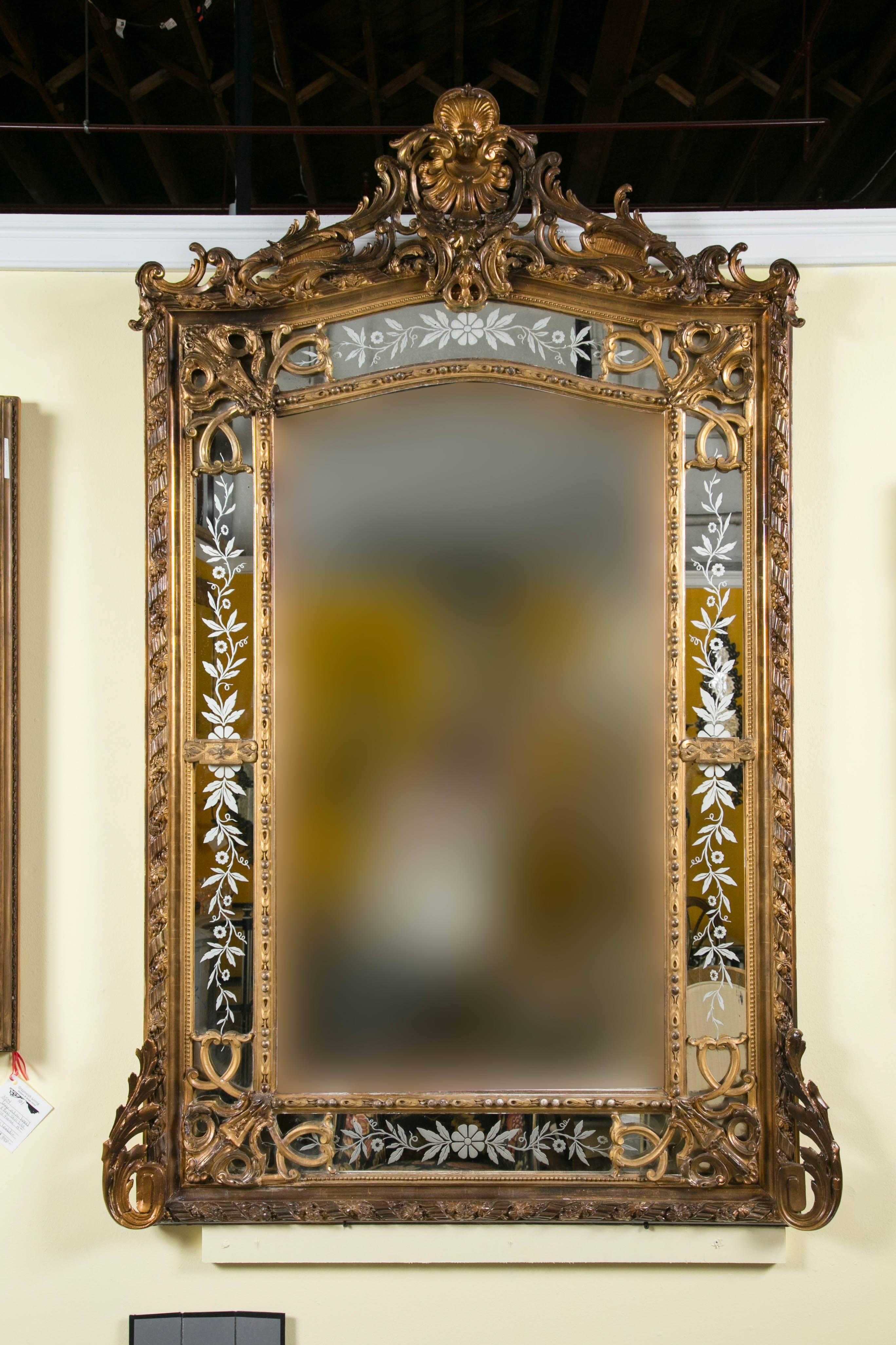 A 19th century French gilded wood and gesso monumental wall / over the mantel mirror. If a statement is needed this is certainly the mirror to make it with. The beveled center framed flanked by four panels of etched glass floral design mirrors. The