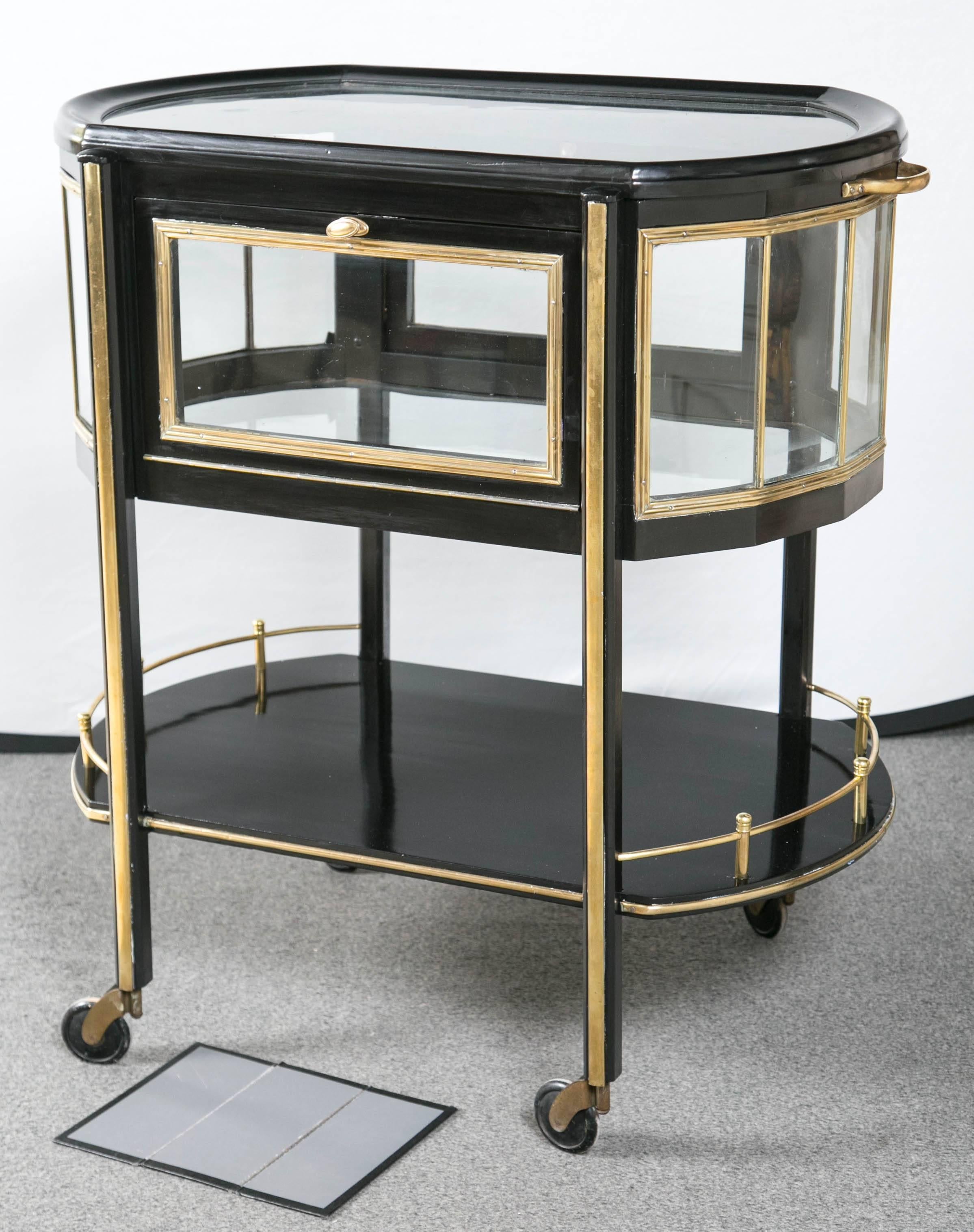A German lacquered brass and mahogany ebonized drinks trolley by Ernst Rockhausen, second quarter of the 20th century. This ebonized tea cart or rolling trolley is absolutely breathtaking. The casters allow the whole to roll effortlessly around