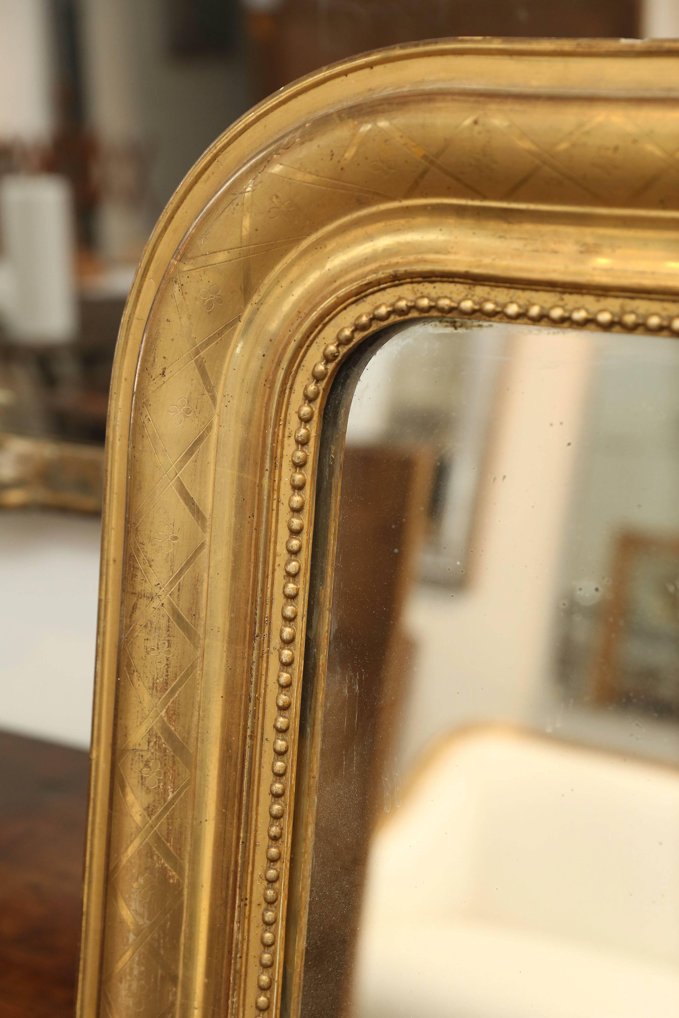 Antique large 19th century Louis Philippe mirror with pearls around the entire inside perimeter and a criss-cross lattice pattern around the larger border. Beautiful gilt patina. Original mercury glass.