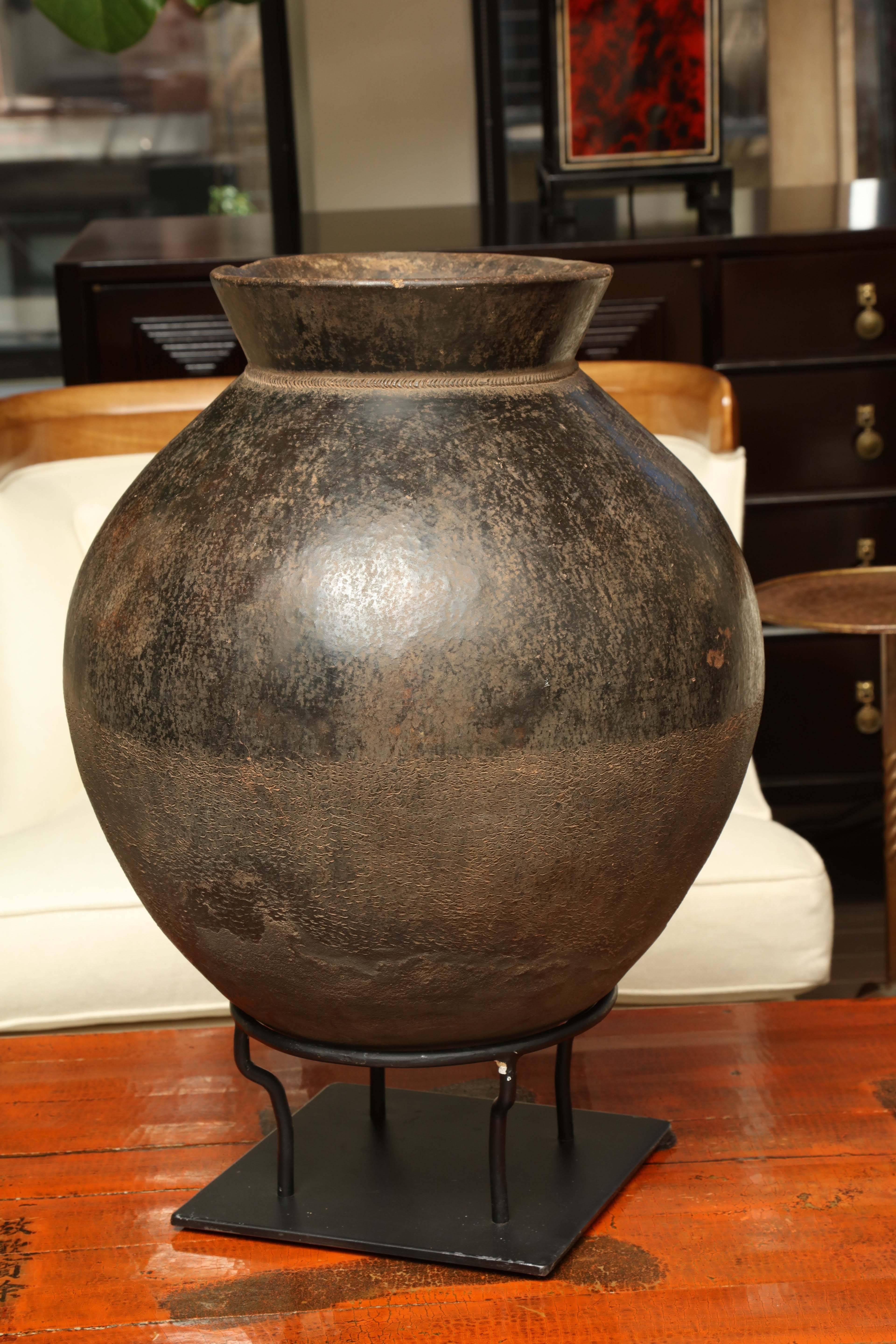 Mid-Century terracotta pot cradled in an iron stand from Burkina Faso, West Africa.