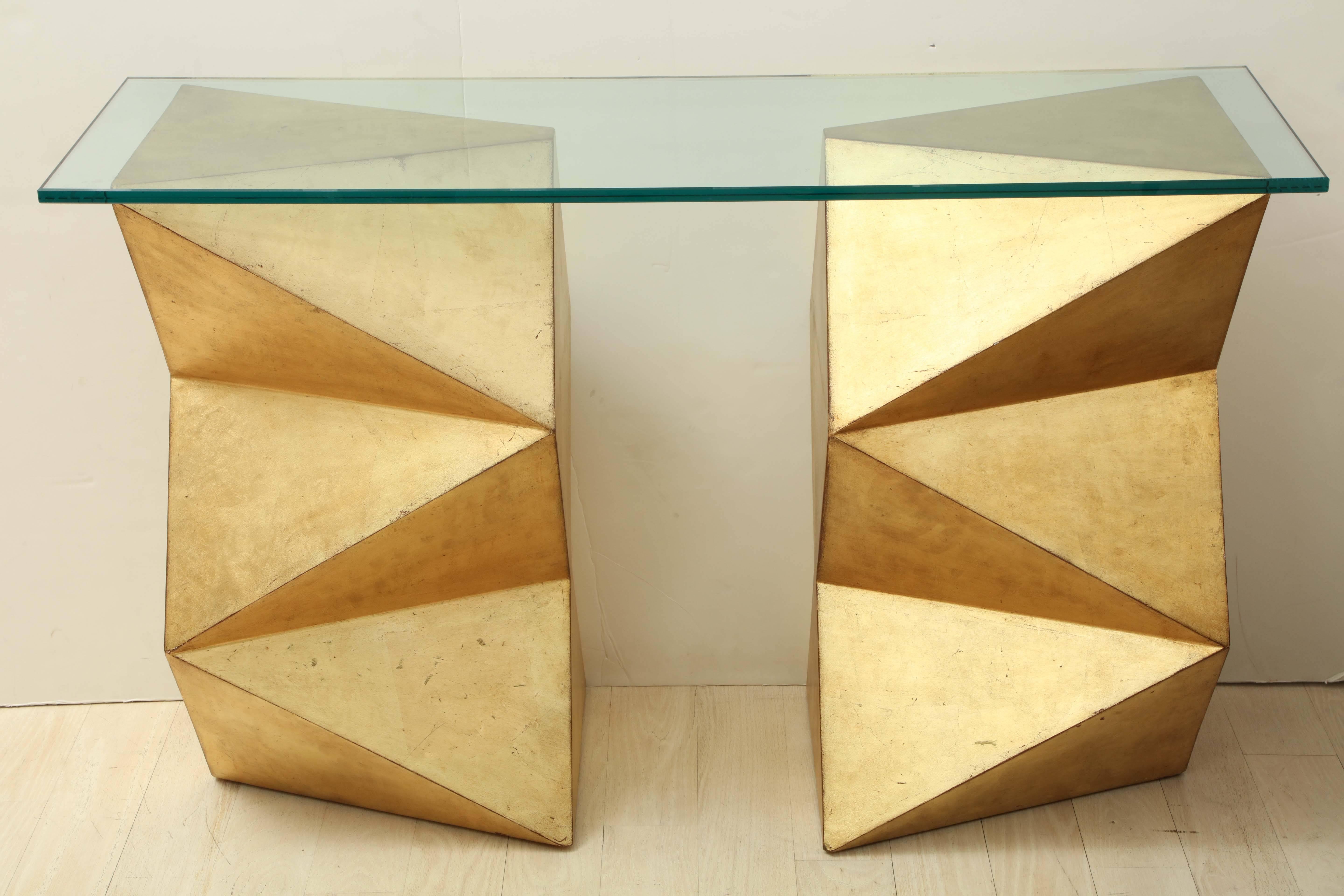 1970s French giltwood and glass console table, the rectangular glass top sitting on two geometric form supports.

Dimensions:
Each support: 16