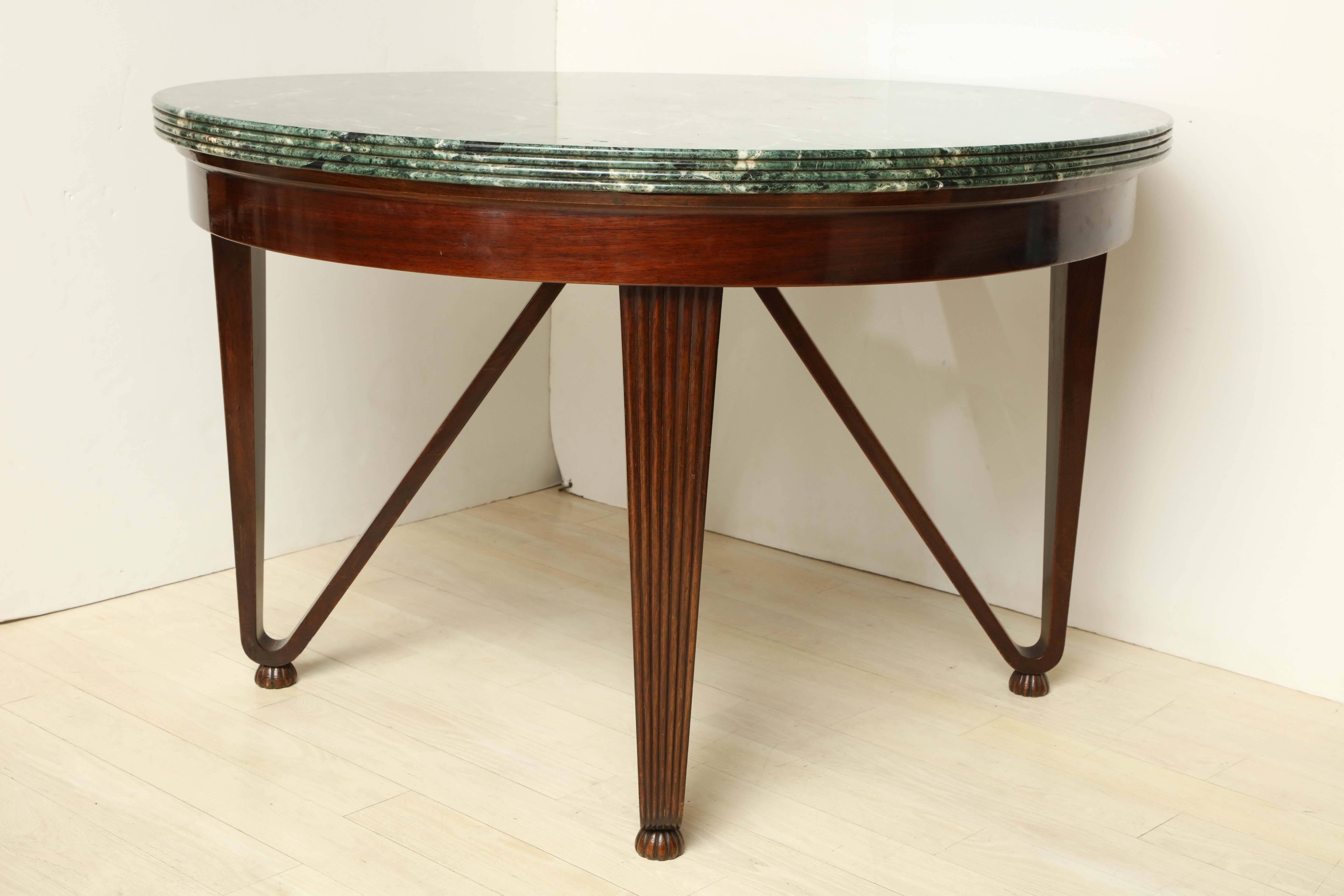 Large, round mahogany center table with tapering, sculpted legs and original green marble top with ribbed edge, Italian, circa 1960.

Dimensions: 49.25” D, 31”H.