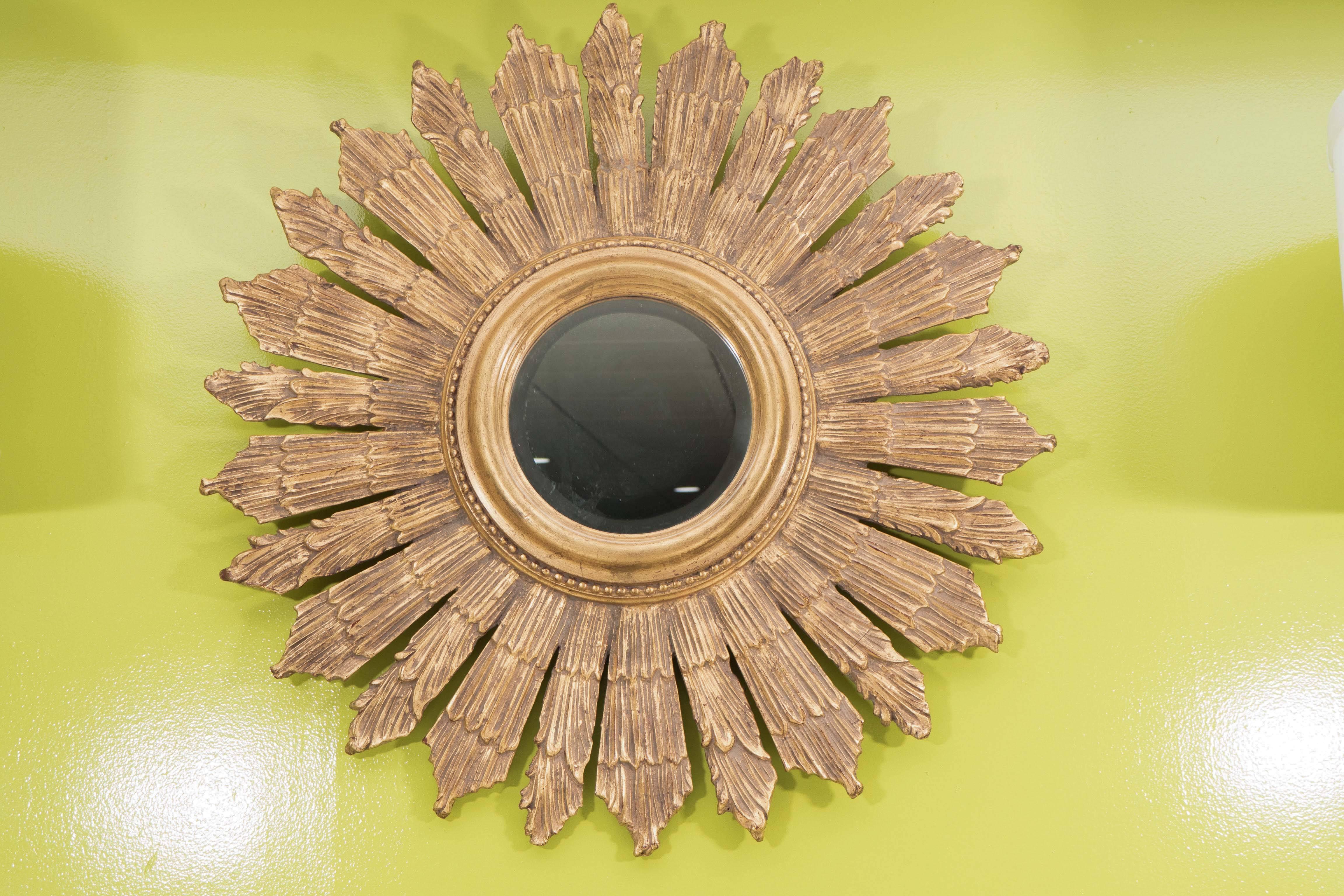 A nice looking French gold sunburst mirror with a molded, center ring framed in in beading and surrounding beveled glass. Fabricated in resin, this piece is solid and sturdy, ready to hang.
