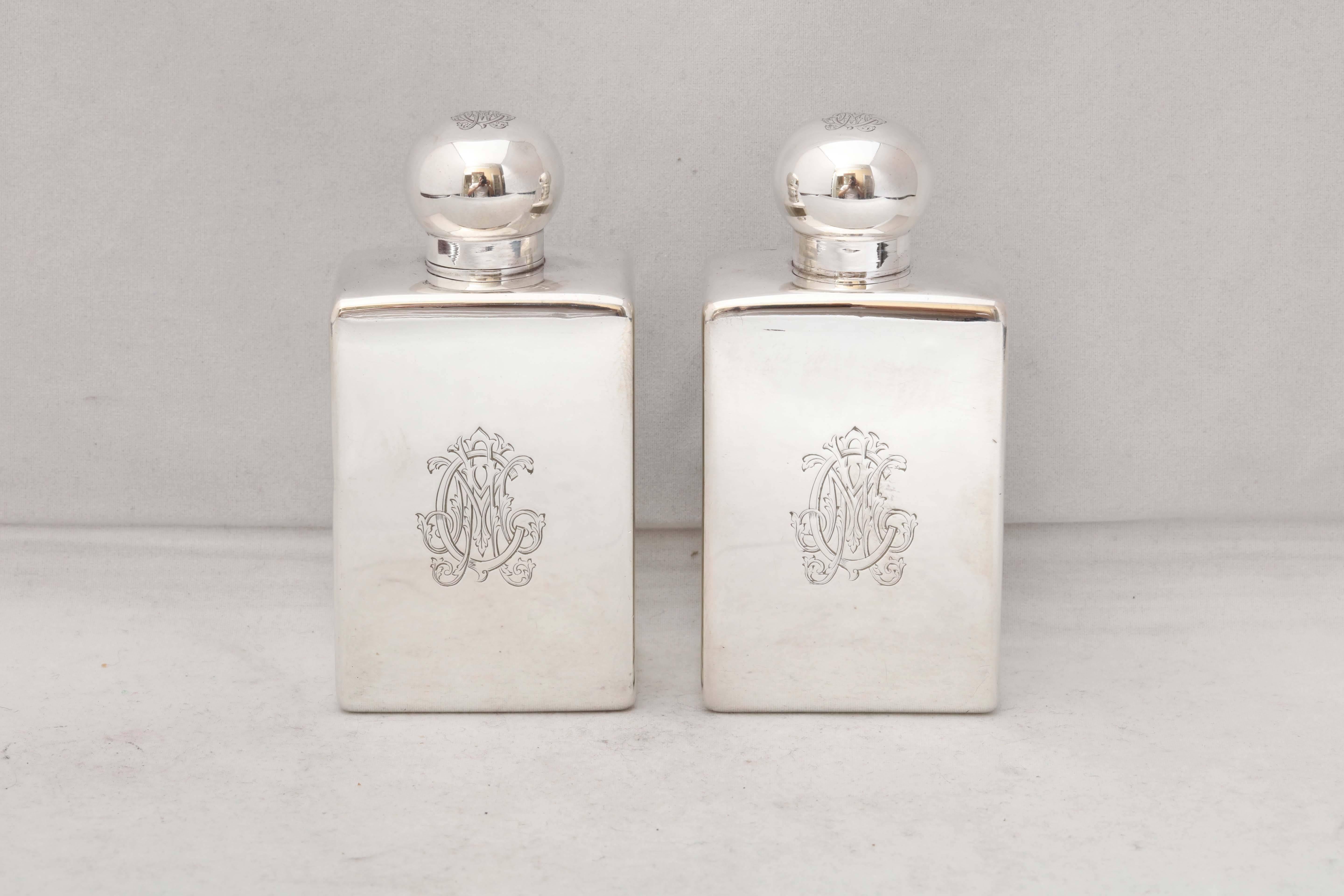 Pair of Edwardian, all sterling silver cologne bottles, Paris, circa 1910, Gustav Keller - maker. Sleek style; beautiful monogram (interlocking C & M) on front and on top of lid of each bottle. Lids unscrew. One bottle has a sterling silver stopper;