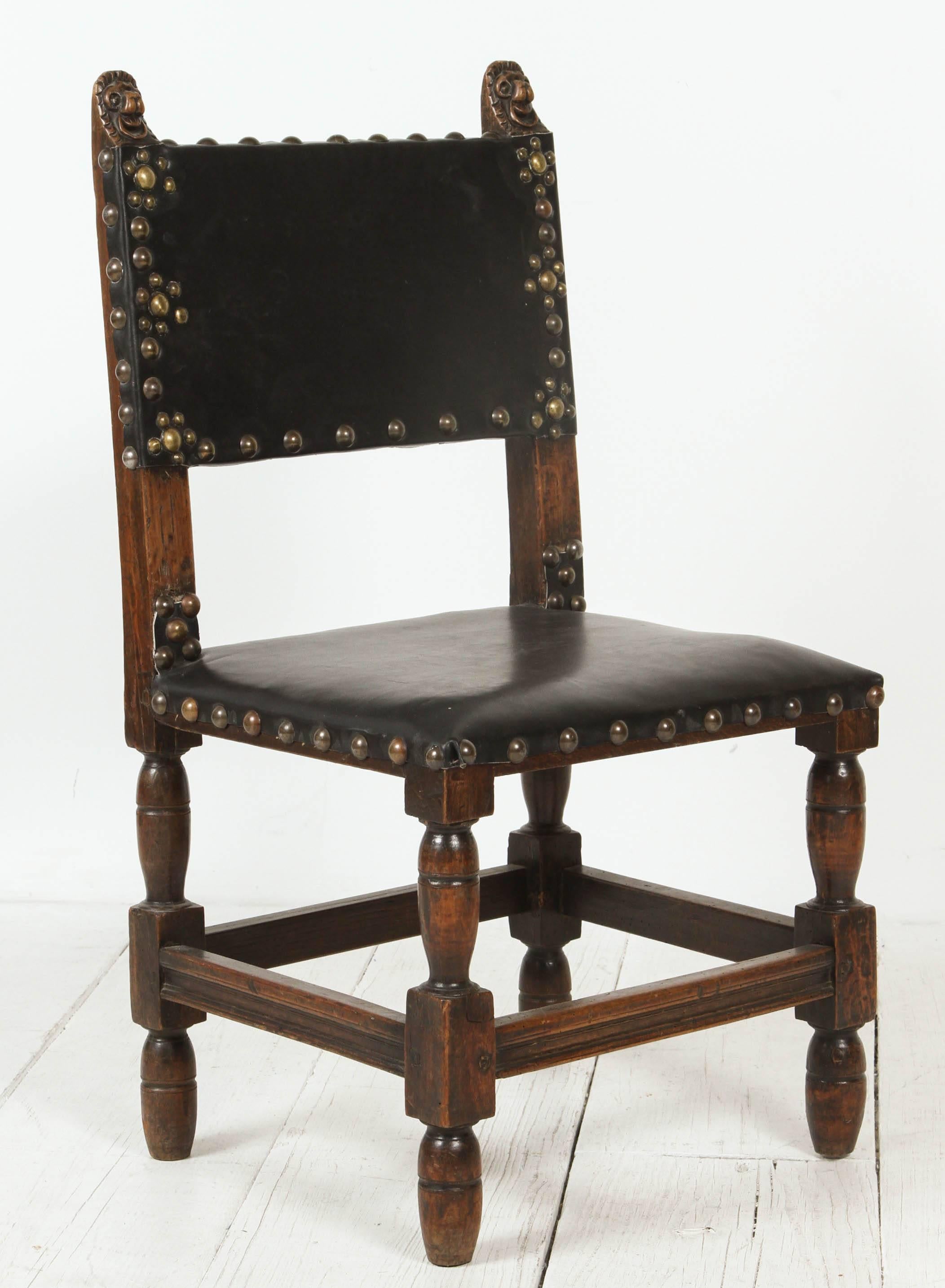 Wood framed Spanish chairs upholstered in leather finished with nailhead embellishment.