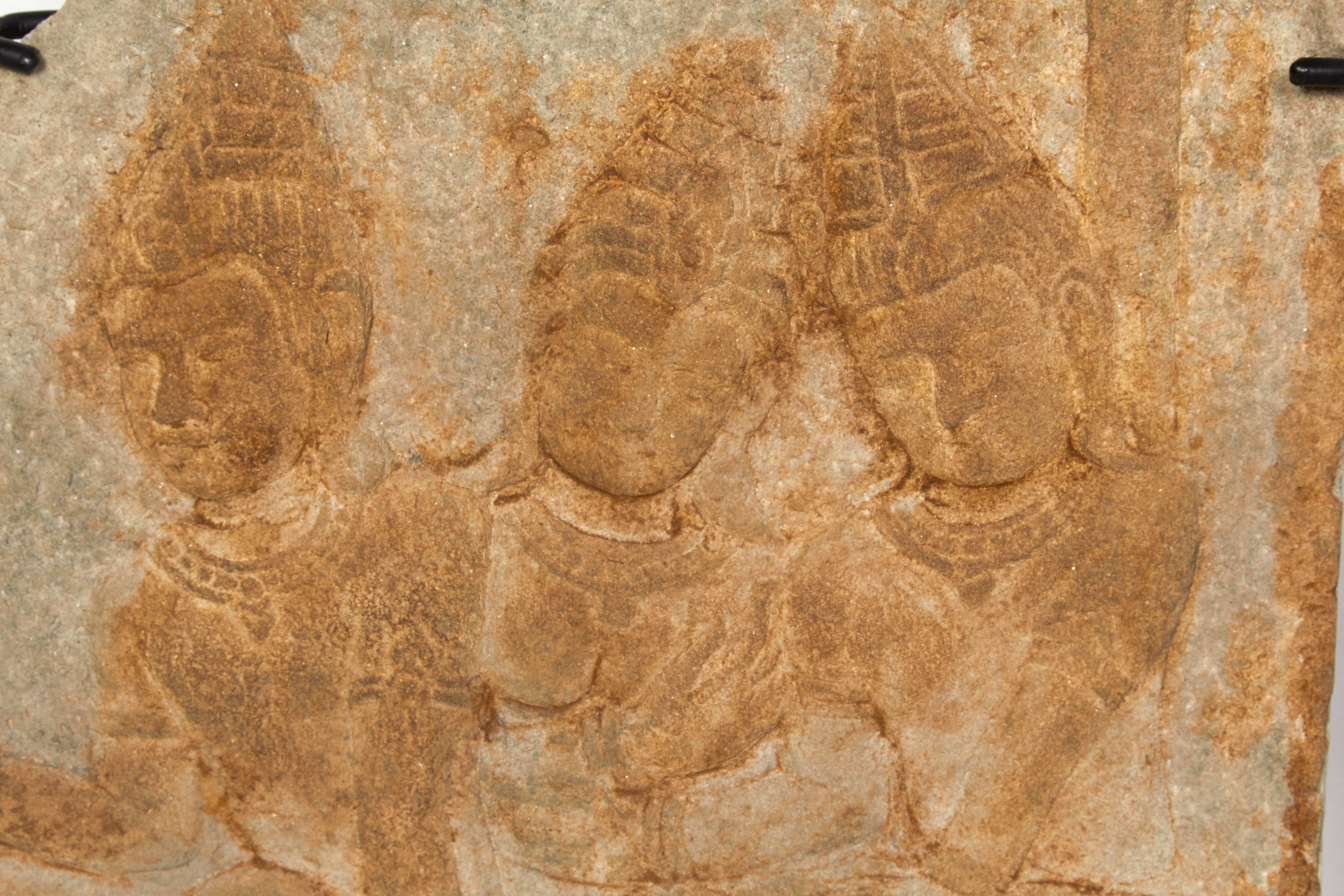 A pair of carved sandstone wall fragments depicting religious caricatures: Three holy men and a Hindu 