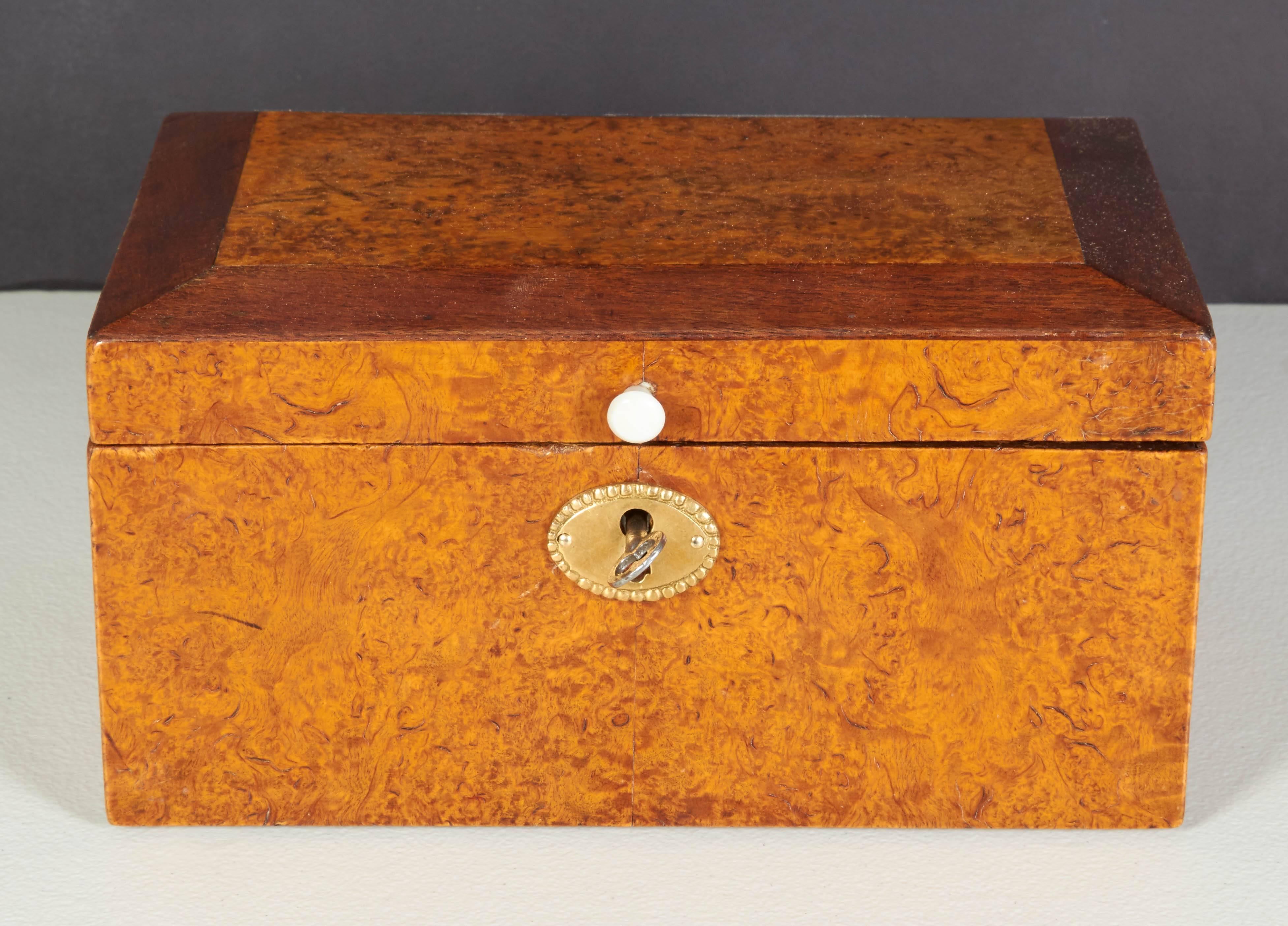 A Swedish birchroot and mahogany crossbanded box, circa 1830-1840, the rectangular hinged locking top with canted mahogany sides.