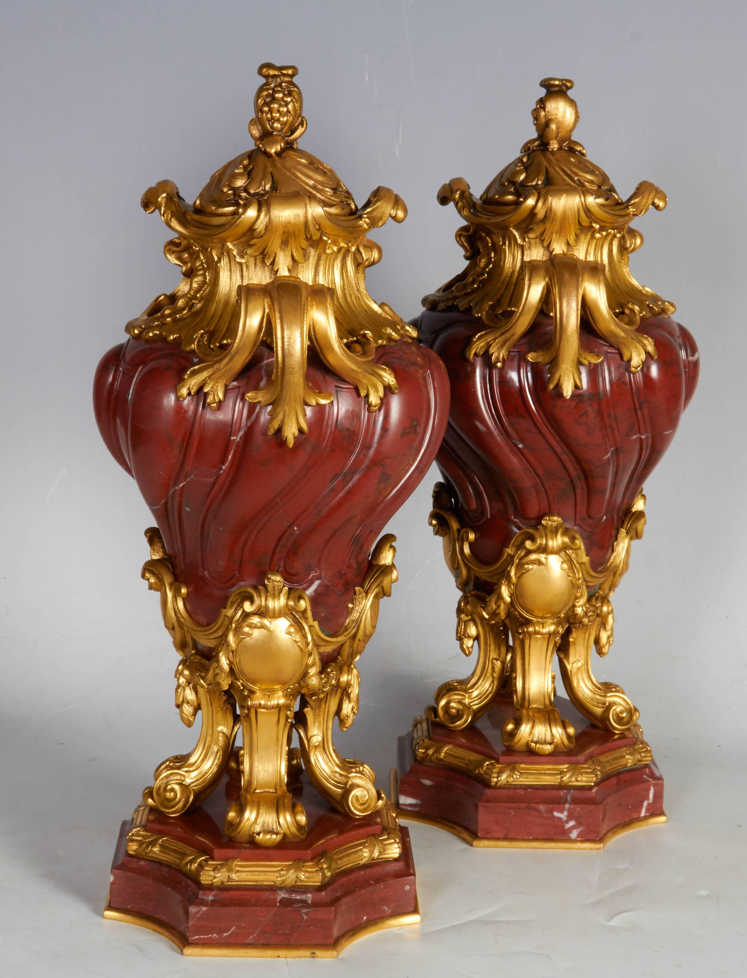 A pair of antique French transitional ormolu-mounted rouge griotte marble covered vases or urns
Last quarter of the 19th century attributed to Henry Dasson
Each with domed lid with a pinecone final, the foliage scroll handles above the spiral