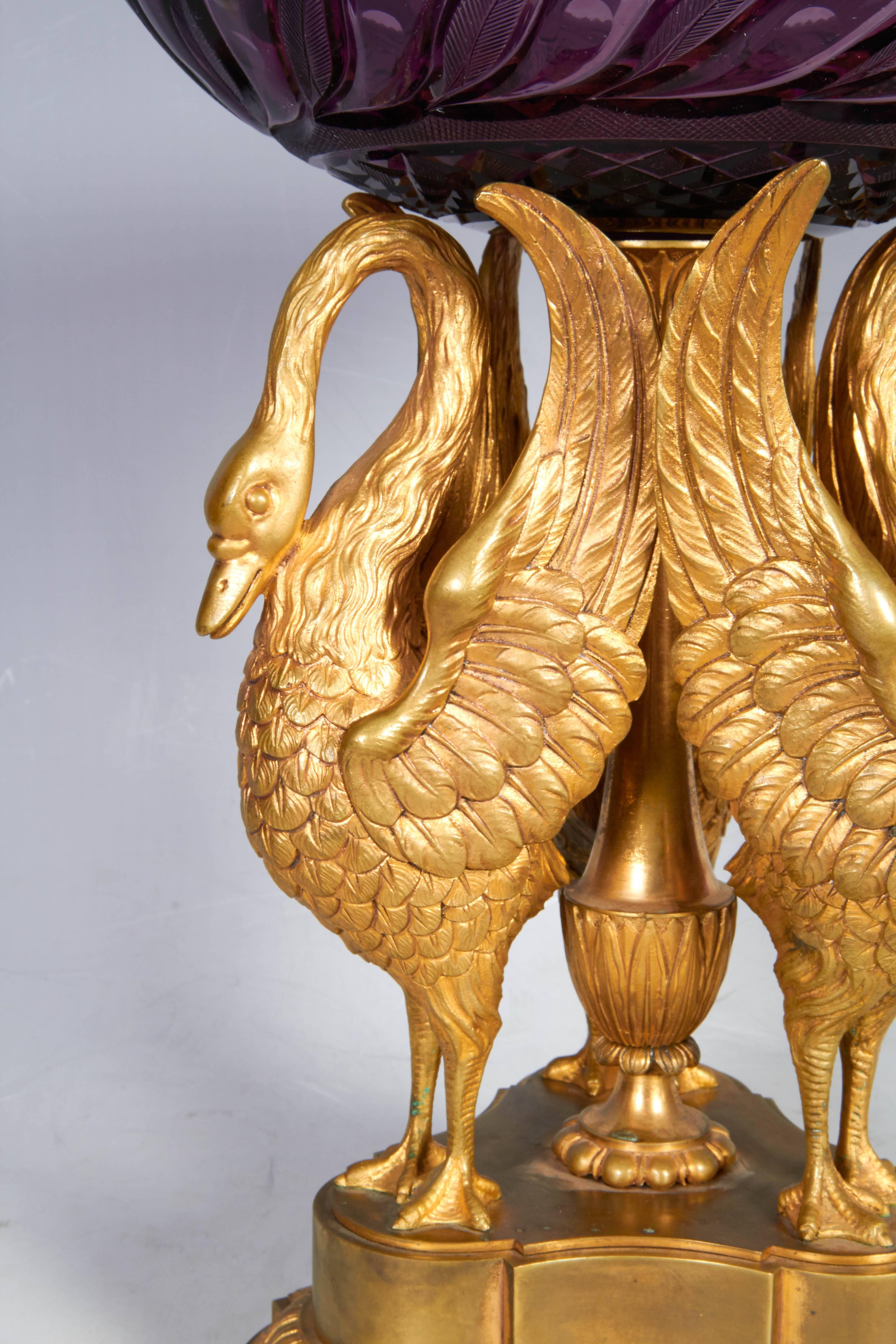 A Russian ormolu and cut Amethyst glass centerpiece with three bronze swans attributed to the Russian Imperial glass manufactory, Moscow, mid-late 1800s. The removable cut Amethyst glass bowl sits on an ormolu sculpture of three swans, very finely