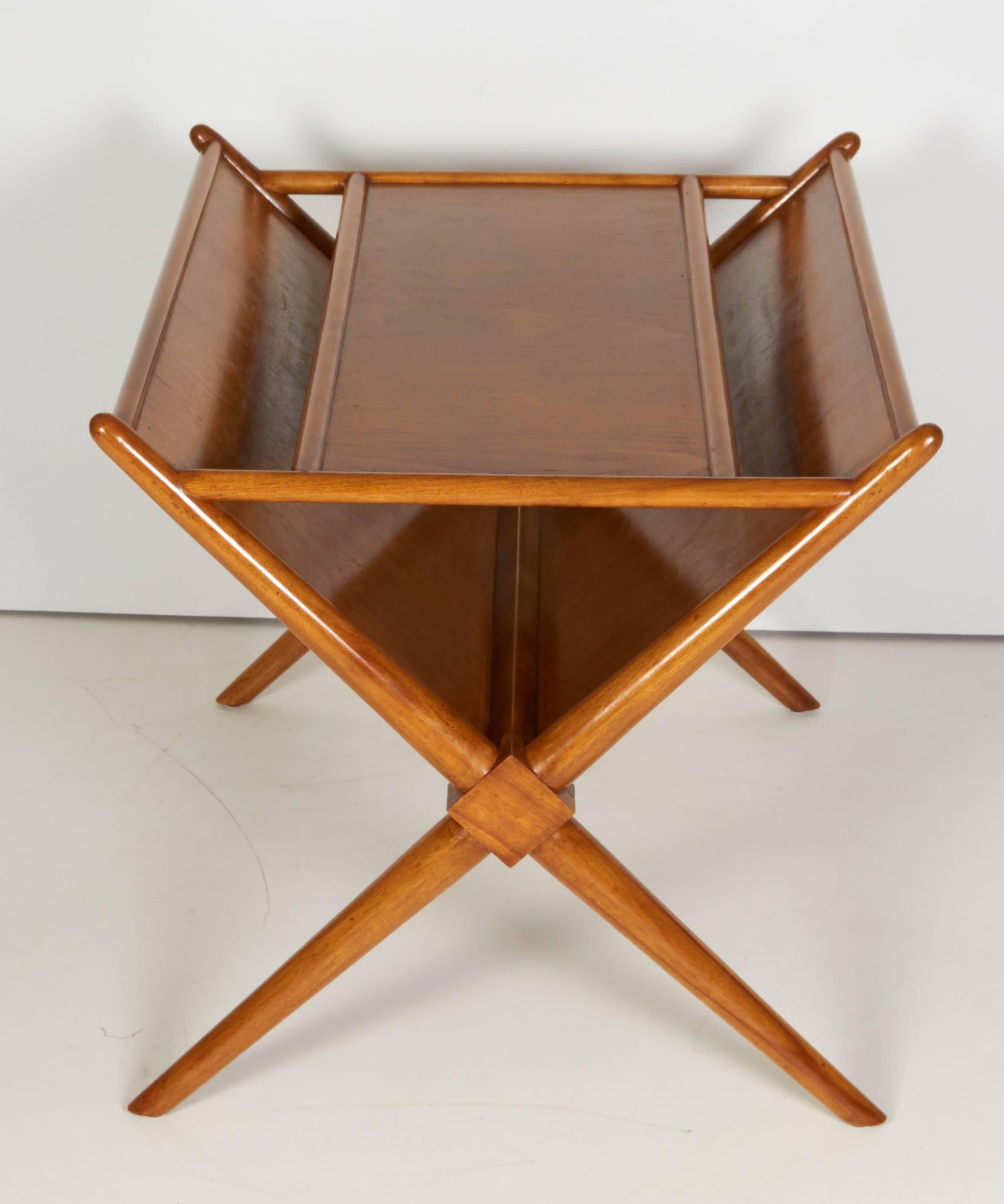 Mid-Century Modern, magazine side table by T.H. Robsjohn-Gibbings, circa 1950. The table has been refinished but it has a few scratches on the top. A light-brown, vintage Mid-century modern X base magazine table made of hand carved mahogany and