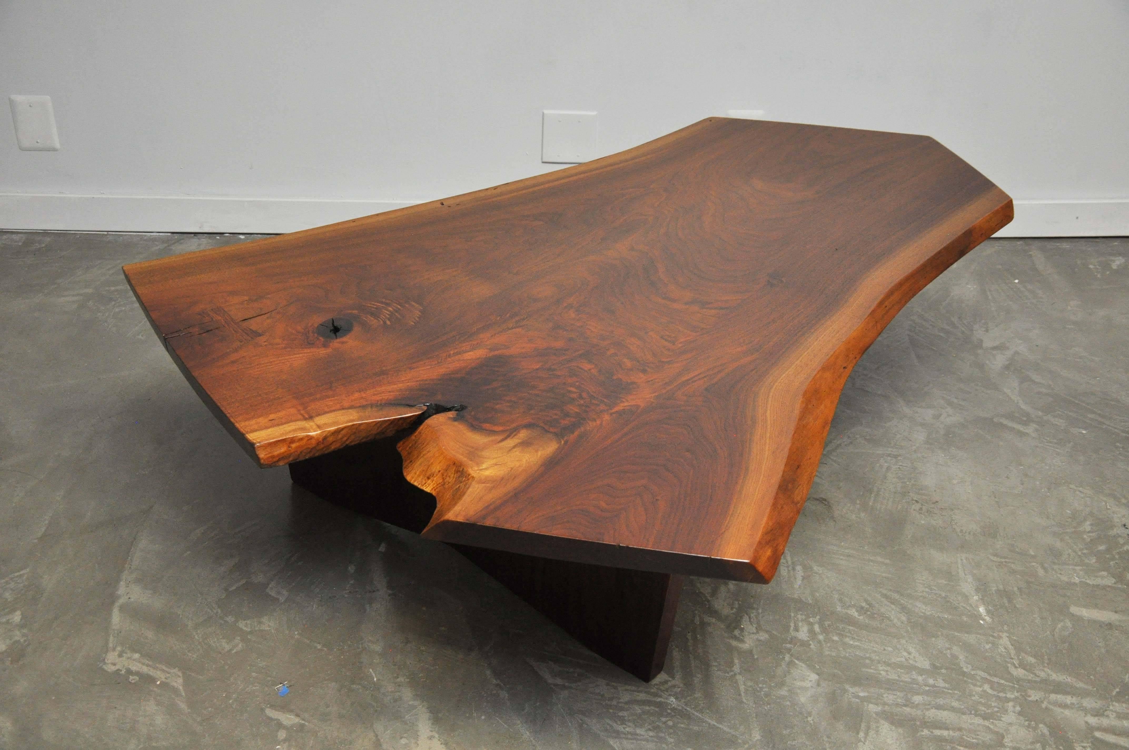 Walnut slab conoid coffee table by George Nakashima, circa 1960s. Beautiful wood grain, knot and patterning, with original rosewood butterfly joint. An incredible piece from Nakashima Studio and a monumental size at 68