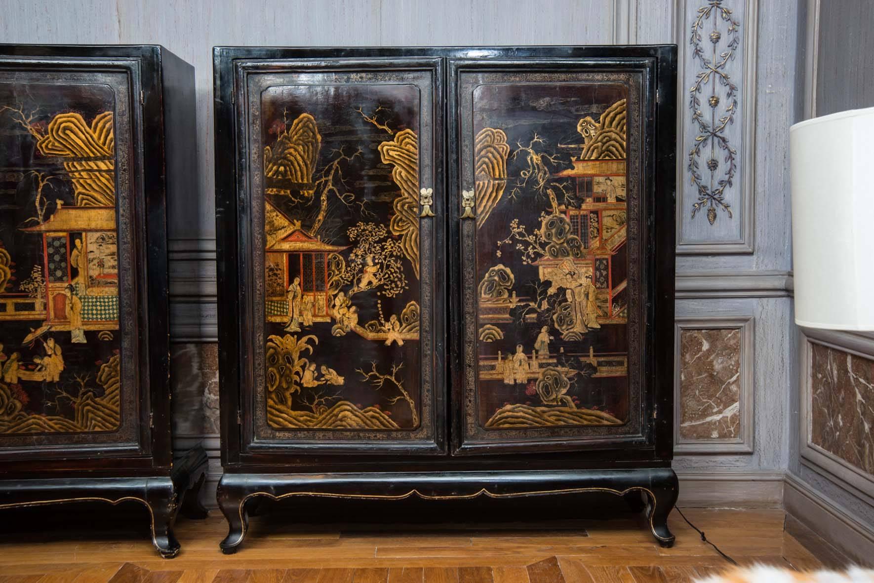 Pair of Chinese lacquered cabinets, black wood, red shelves inside.