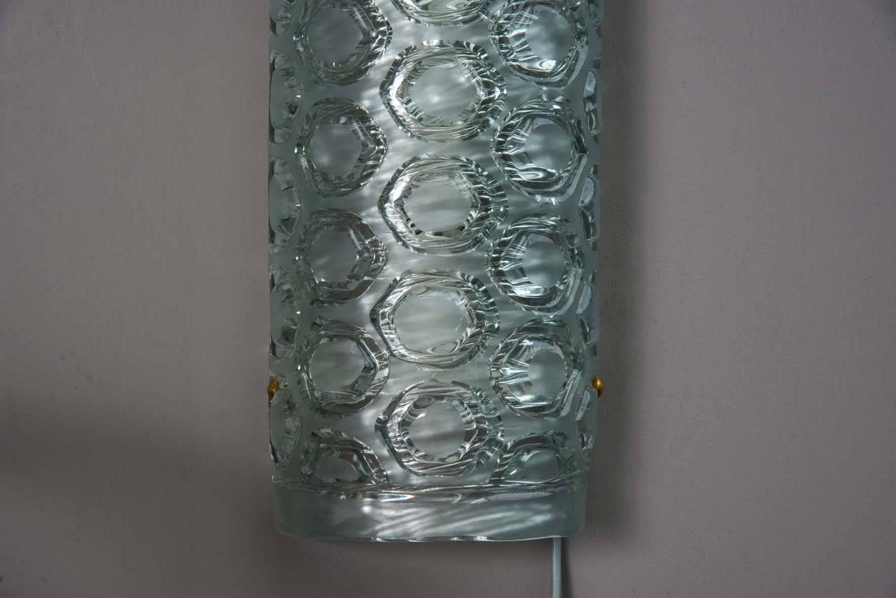 Set of six nice and tall wall sconces, made of a single piece of curved and slightly tinted Murano glass with honeycomb pattern. Supported by a metal structure, each sconce has three sources of light.