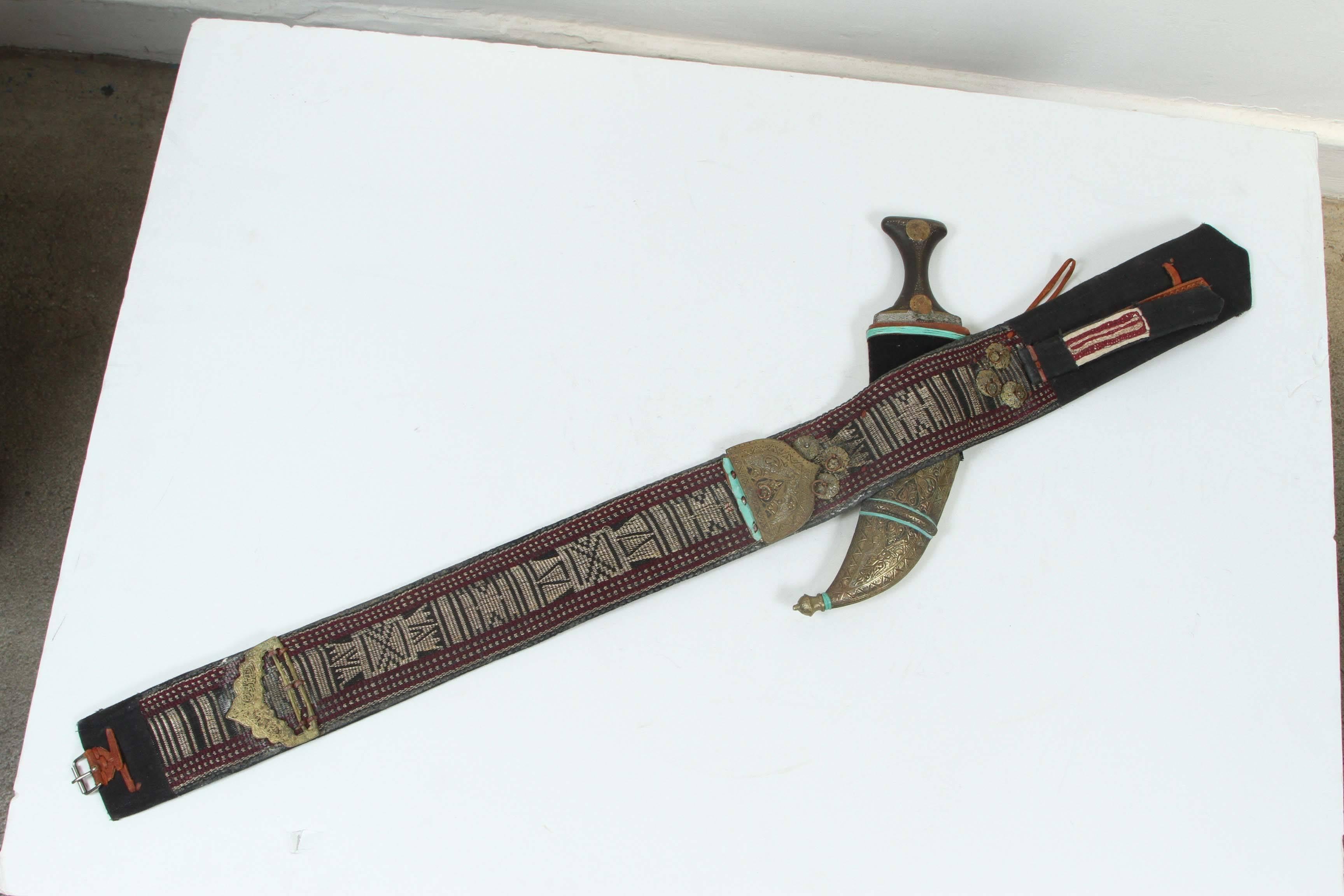 Middle Eastern Yemeni Jambiya, which is the name for the Arabic dagger.
Comes with a very thick hand embroidered belt with intricate designs and ornate with brass hammered element with calligraphy scripts.
The dagger is curved with a tick double