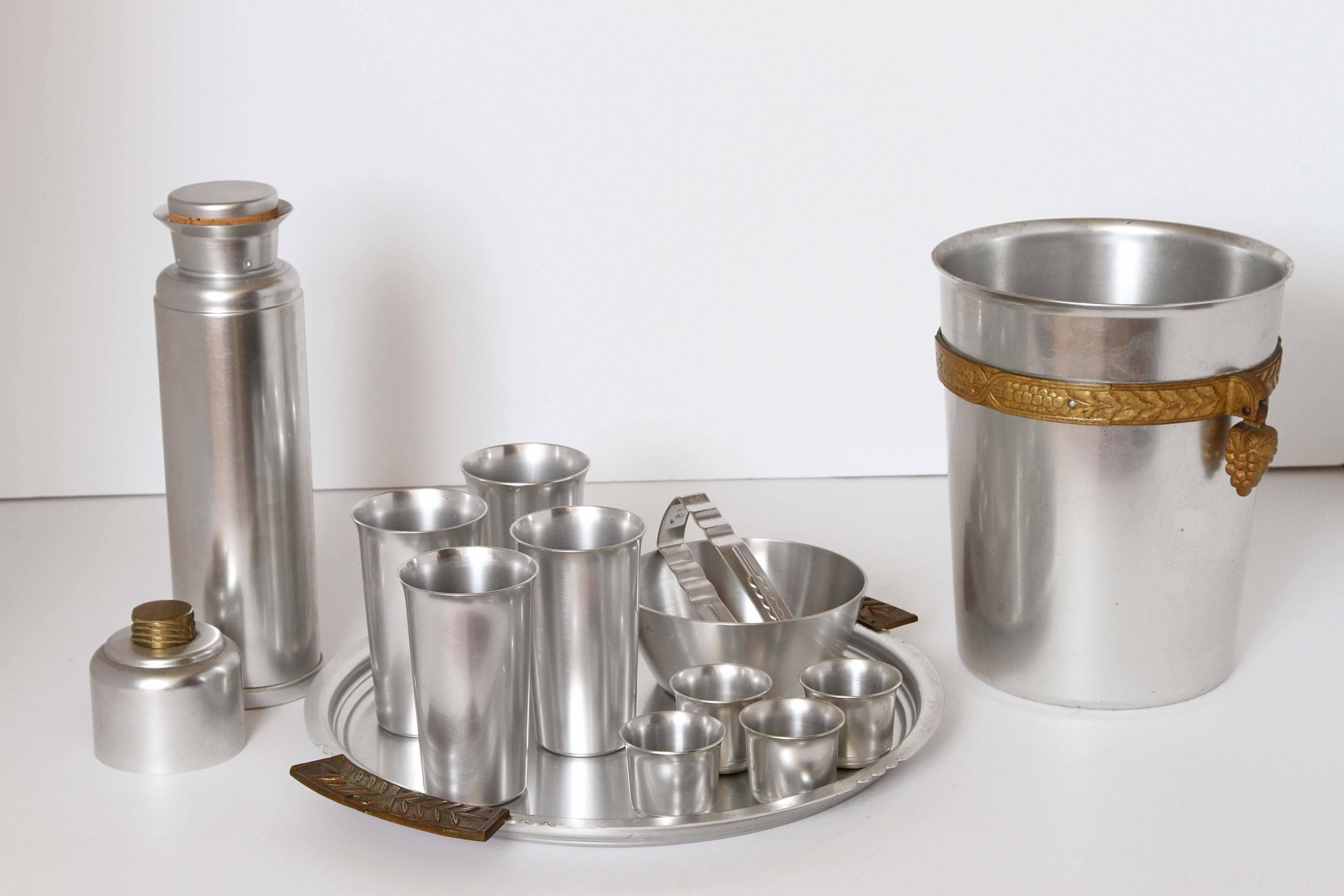 Sizable grouping of Kensington brushed aluminum by Guild, in good vintage lightly-used condition.

Large coldchester shaker, large laurel tray, four coldchester juleps, four coldchester cordials and rare coldchester champagne / wine bottle