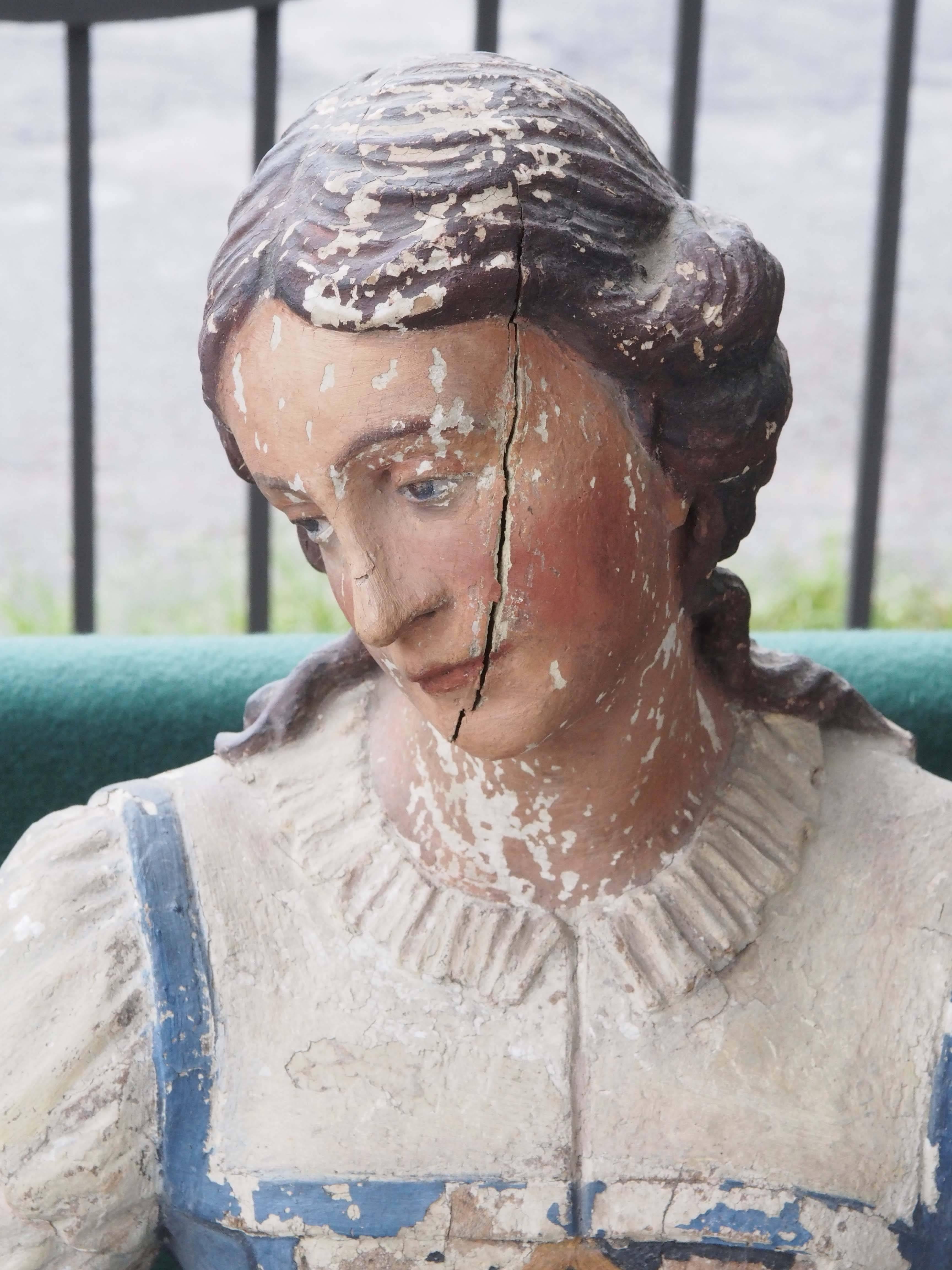 19th century polychromed carved wood statue of woman with loaf of bread, sicle and float.
 