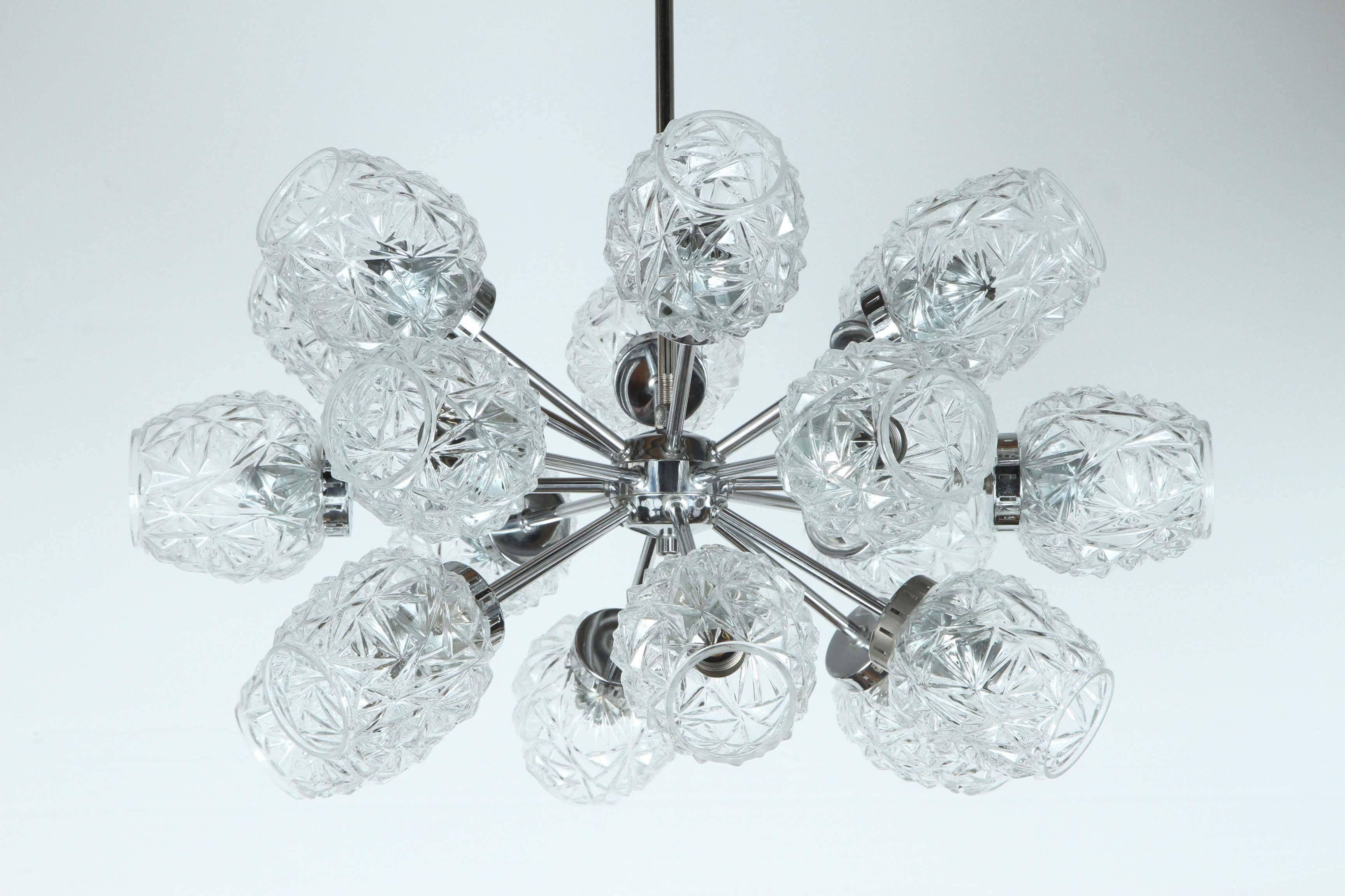 Unusual German Sputnik chandelier with cut glass elements.
The eighteen-arm polished chrome frame which has been newly rewired for the US takes candelabra light bulbs each with a 15 Watt maximum comes complete with a chrome rod and ceiling canopy.