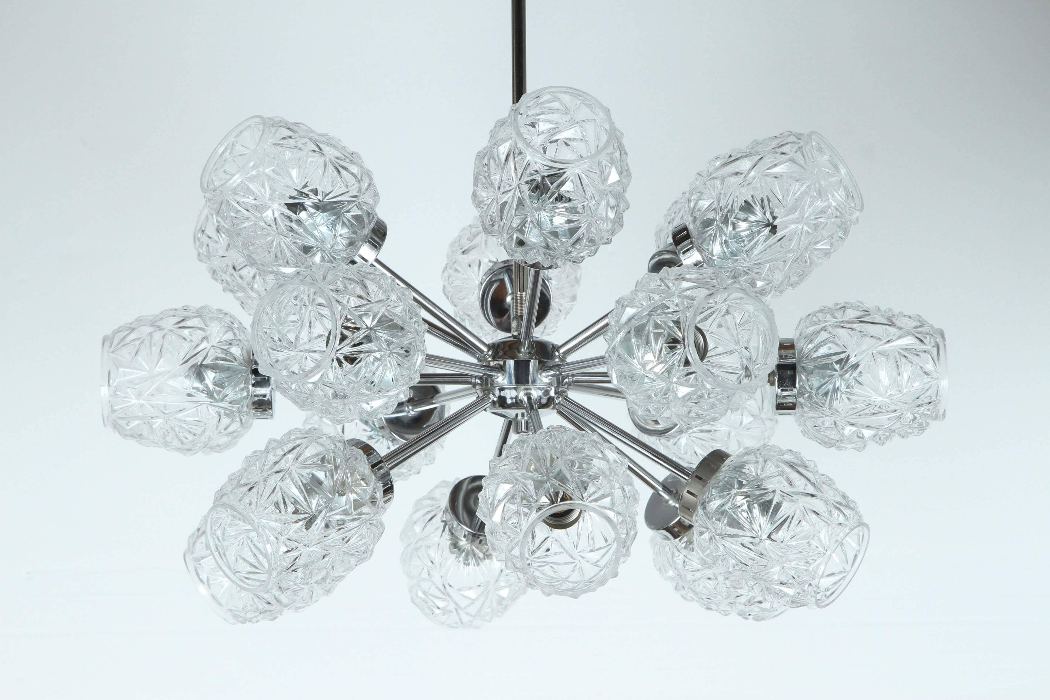 Lustre Sputnik allemand inhabituel avec des éléments en verre taillé.
Le cadre en chrome poli à dix-huit bras, qui a été nouvellement câblé pour les États-Unis, prend des ampoules candélabres de 15 watts maximum chacune et est livré complet avec une