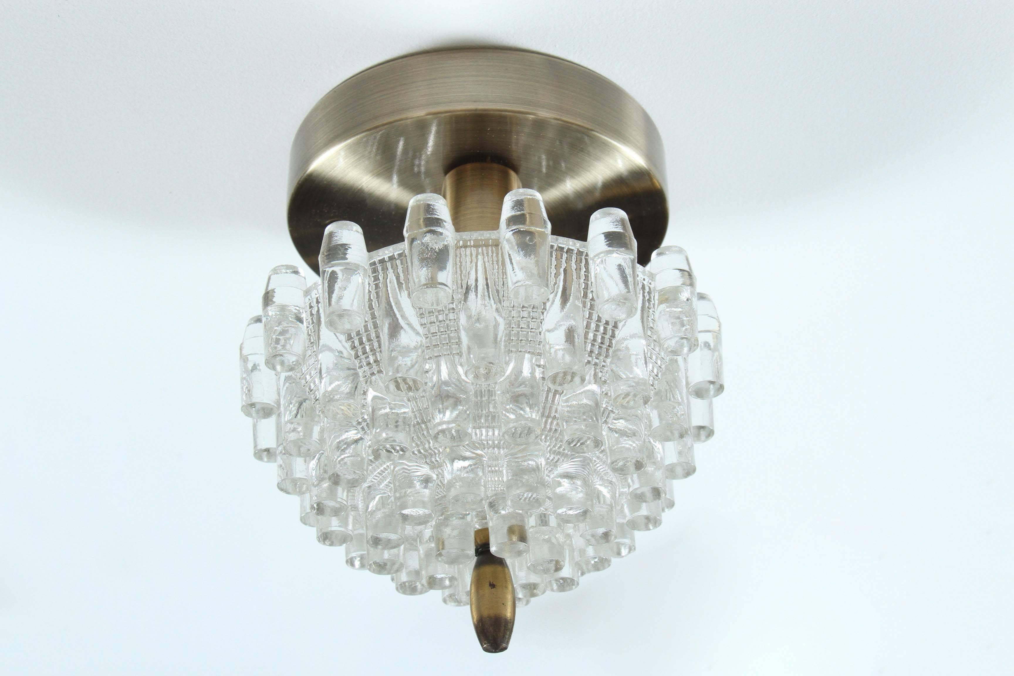 Pair of unusual moulded glass sconces. 
The dome shaped glass element is richly textured, with a deco effect and they are mounted on antique brass wall plates.