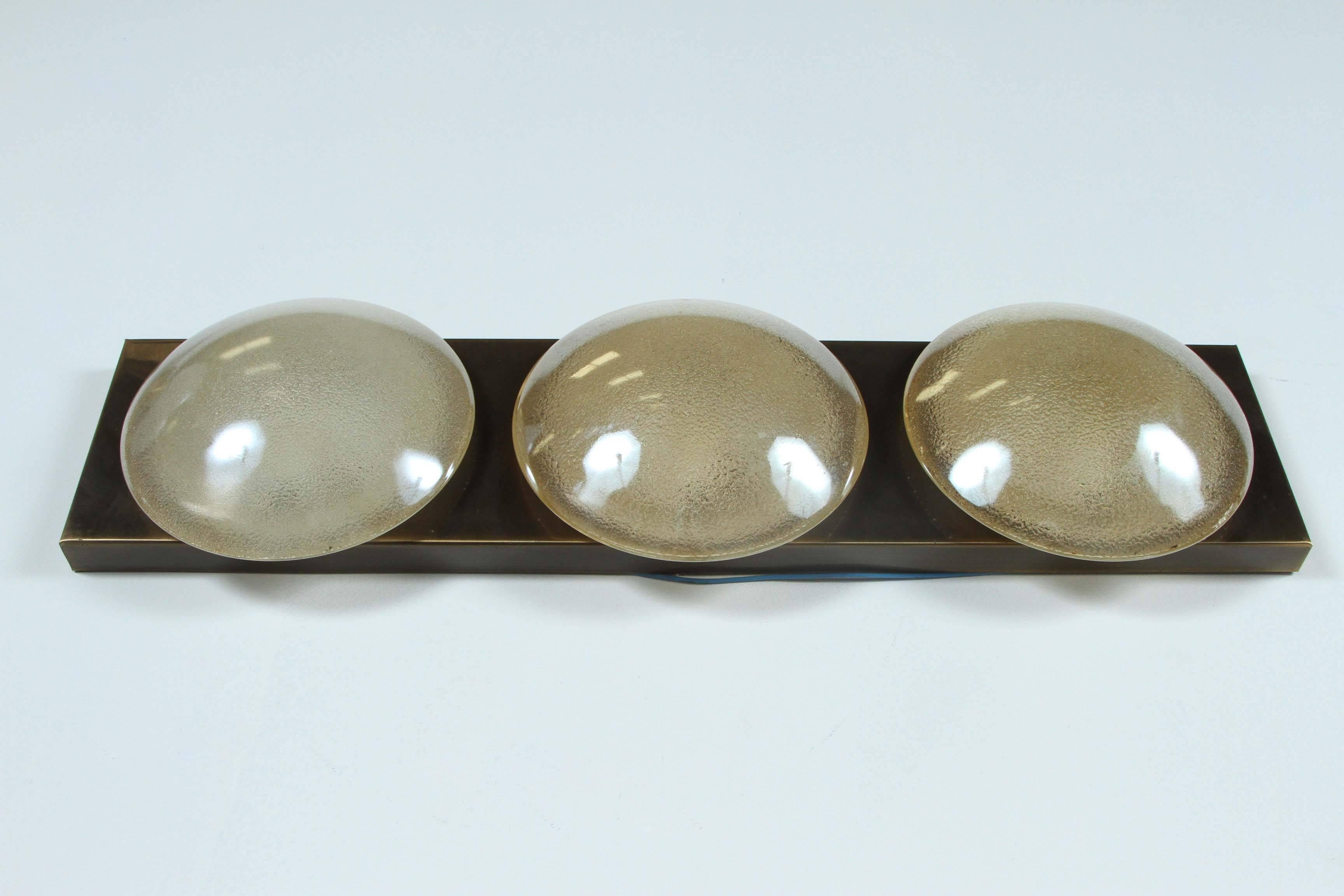 Great flush mount or sconce with three beautiful opalescent glass elements mounted on an antiqued brass fixture by Doria.