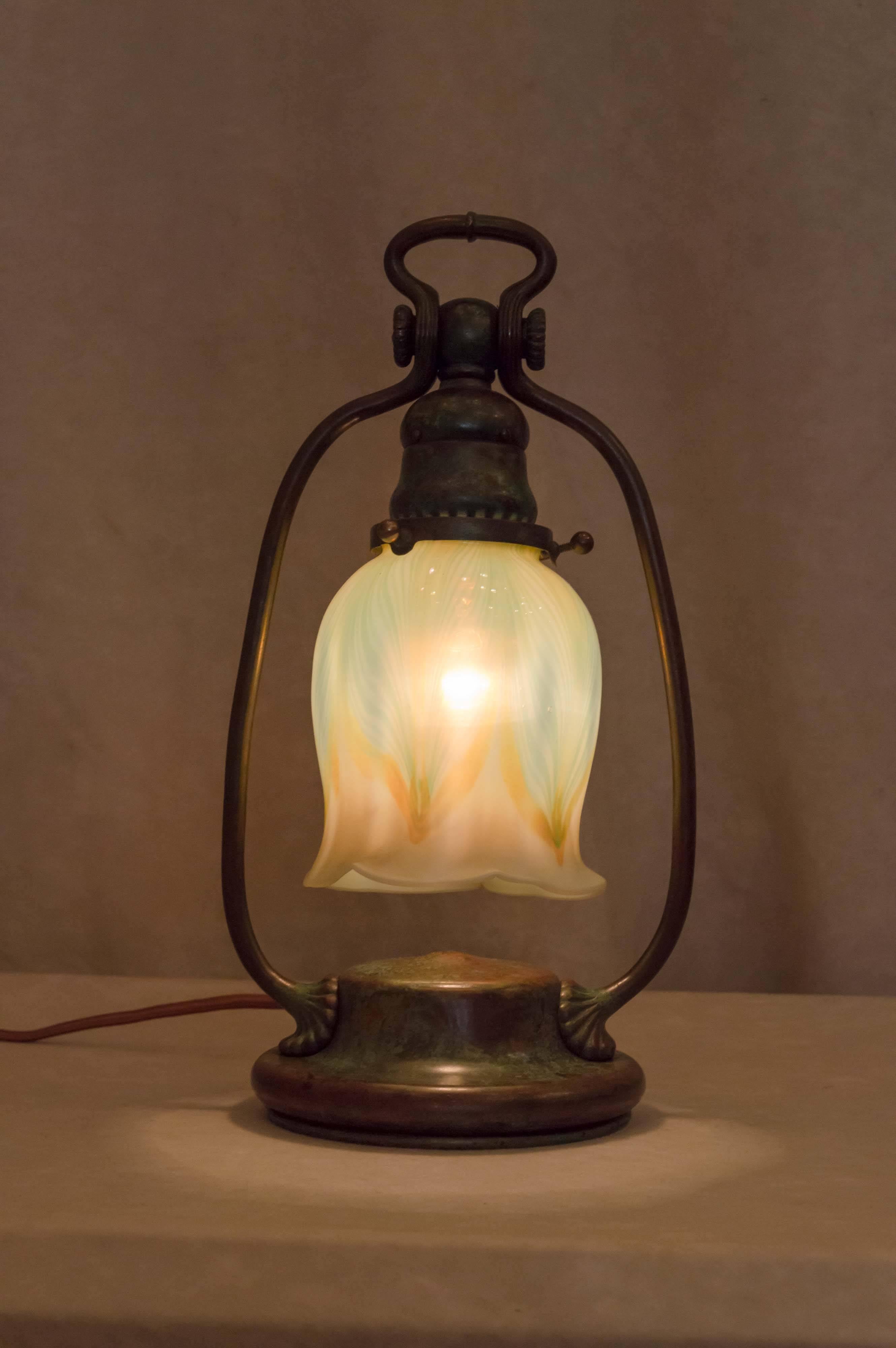 This lovely little lamp can be the perfect accent to any area of your home. Both shade and base are properly signed. This is an authentic guaranteed Tiffany Studios lamp, and not a copy. 
 The base is bronze and beautifully patinated as only