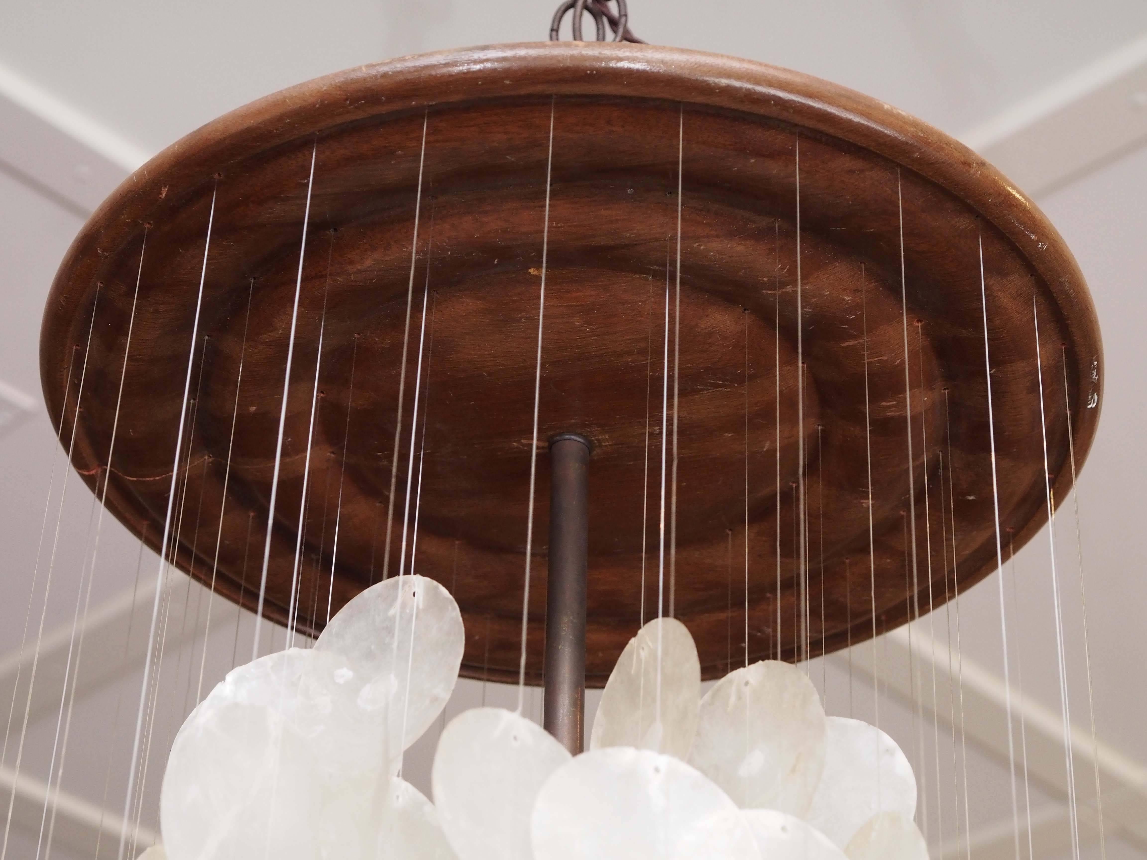 20th century Danish chandelier by Vernor Panton made with capiz shells hanging from translucent wires suspended from a walnut medallion, circa 1960s.