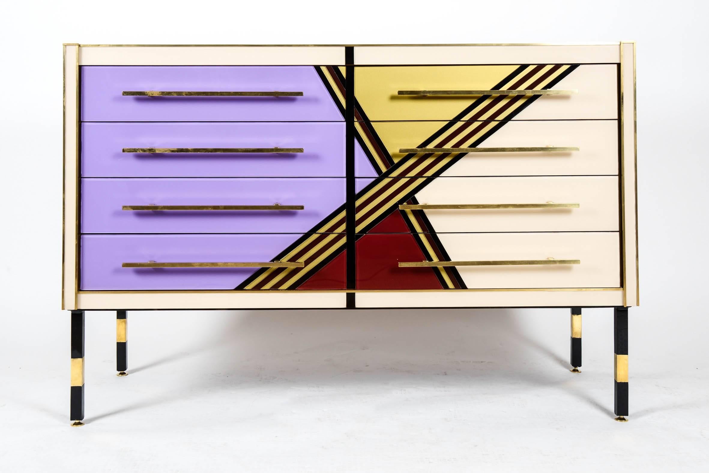 Important vintage mirror commode, front with geometric multicolored drawings, eight drawers, brass and black metal legs, brass handles.