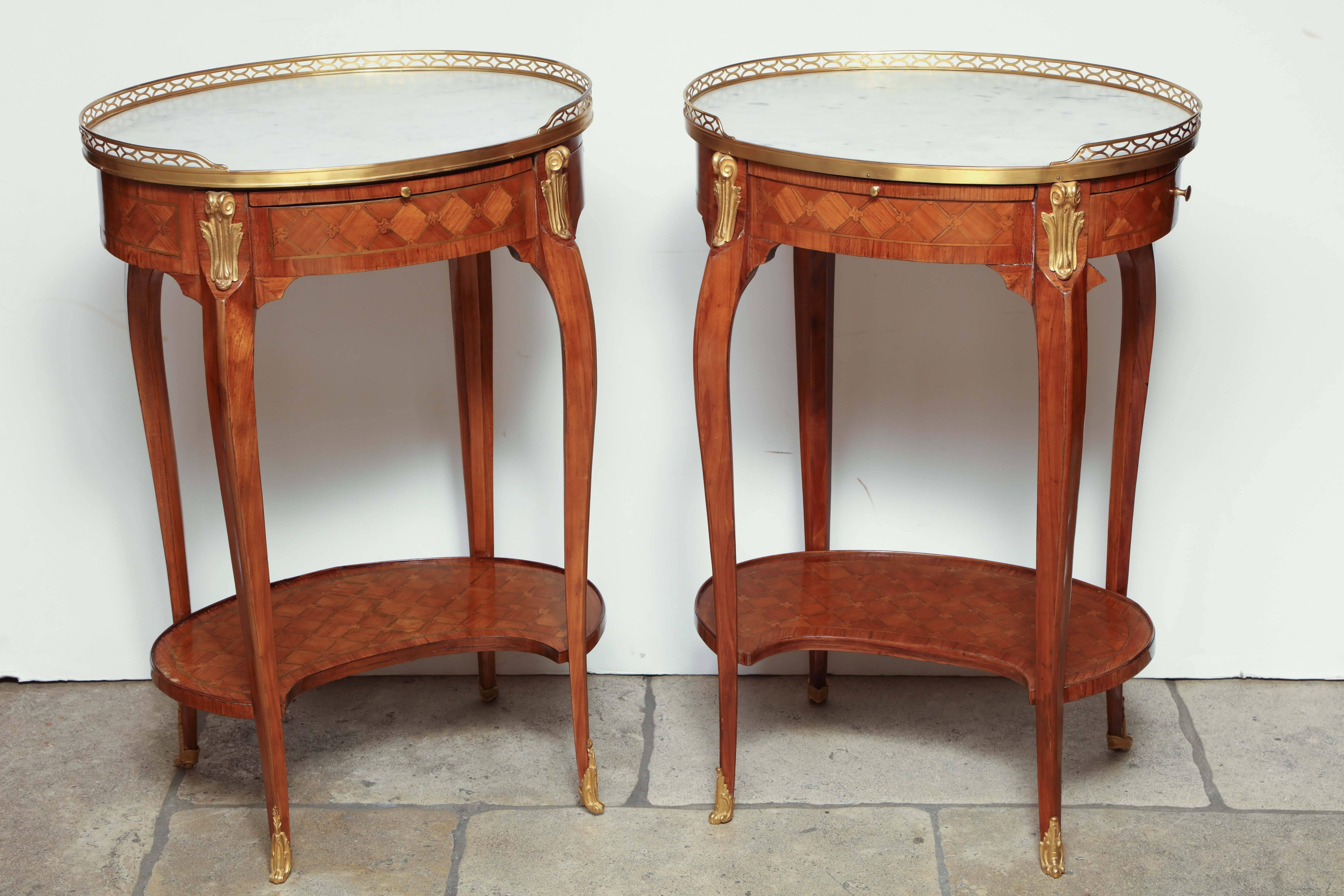 Pair of French oval marble top one-drawer parquetry side tables.